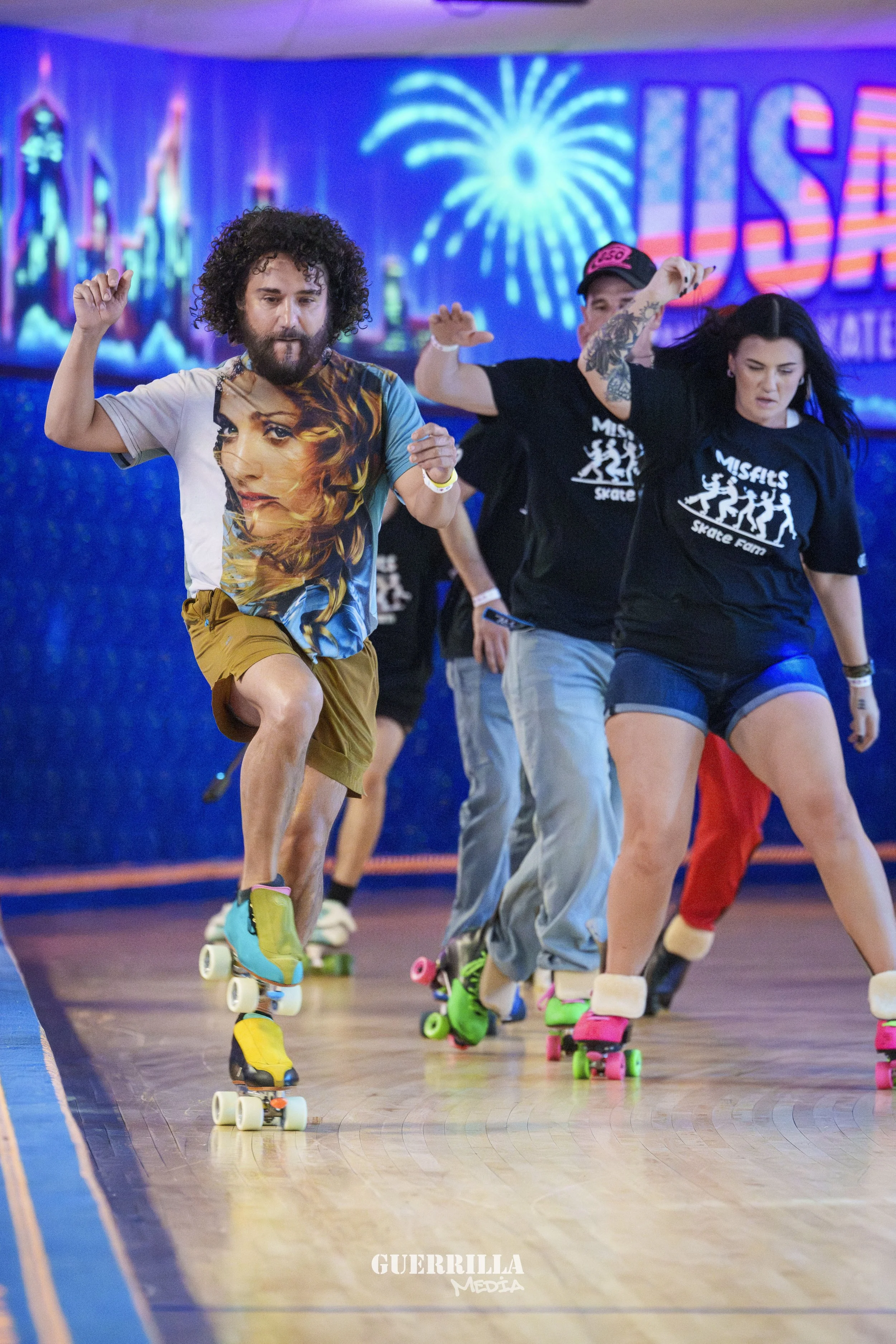 People roller skating indoors with a vibrant cityscape and fireworks mural in the background.