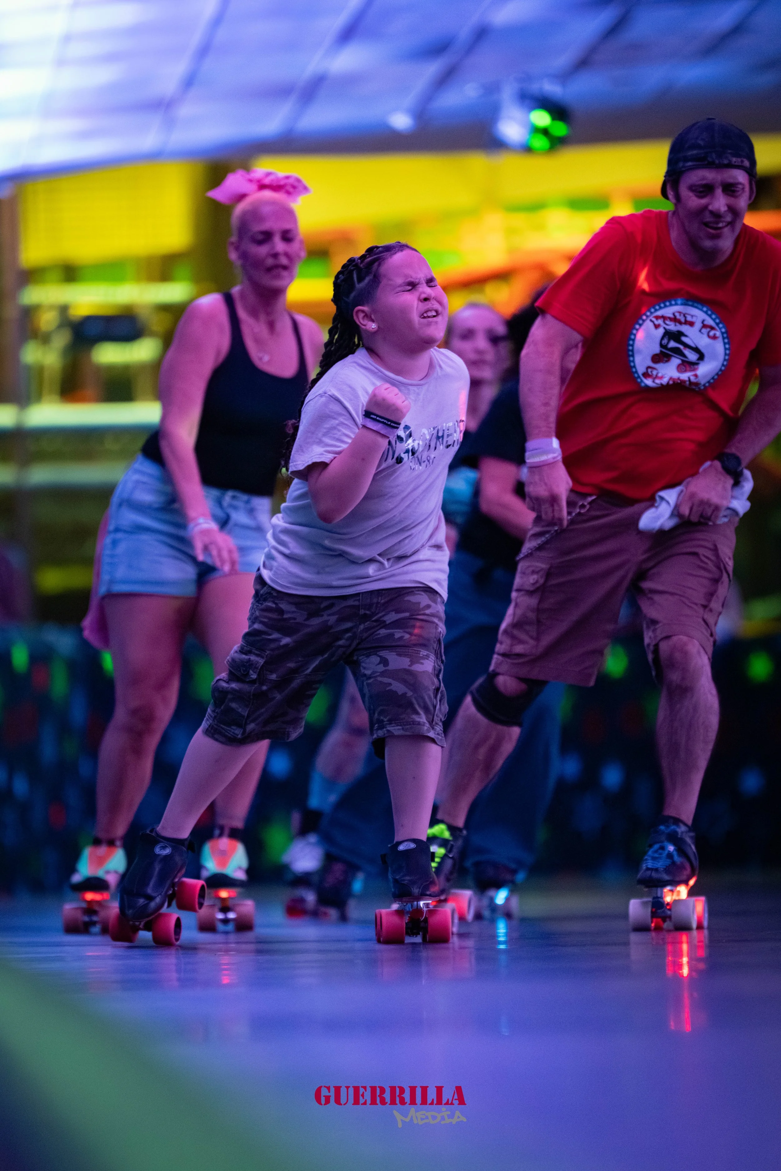 A group of people, including a girl with pigtails, roller skating indoors under colorful lights, with various colorful background elements.
