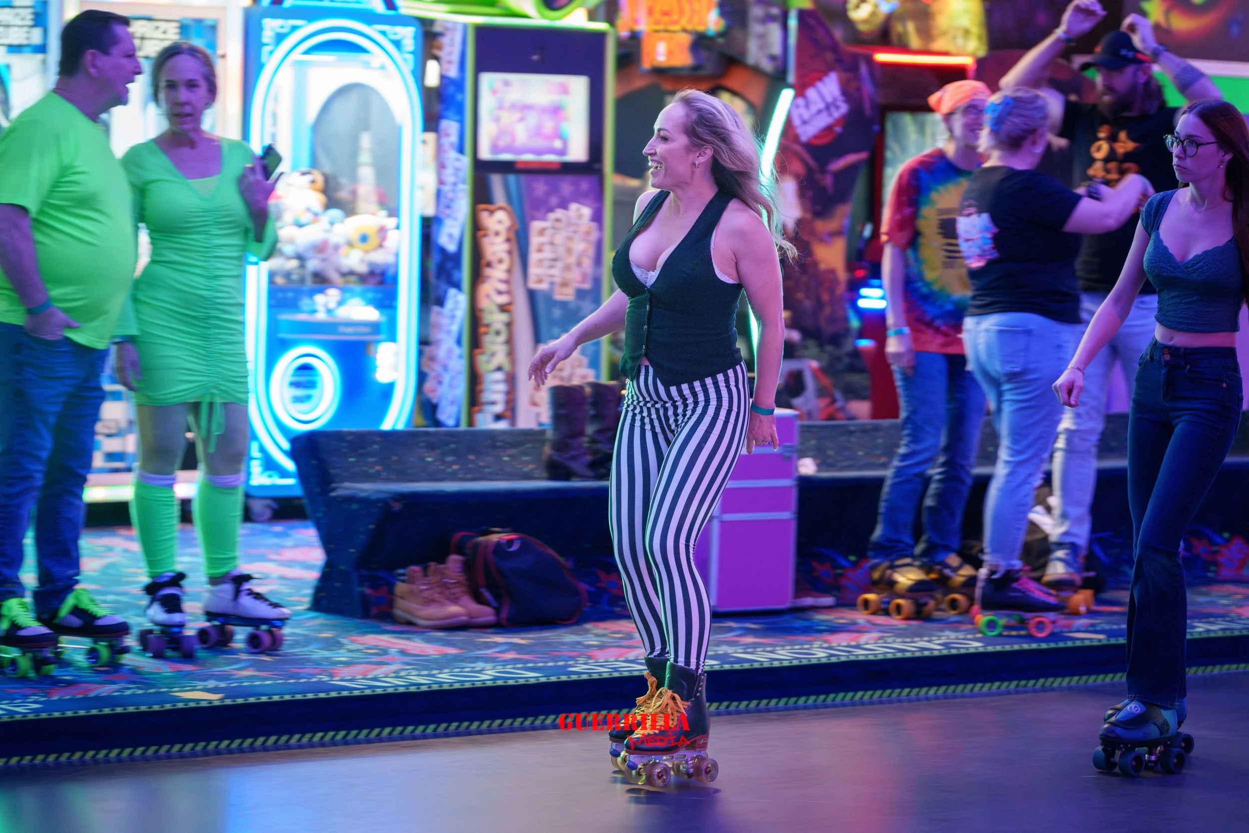 People roller skating at an arcade or entertainment center with neon lights and arcade games in the background.
