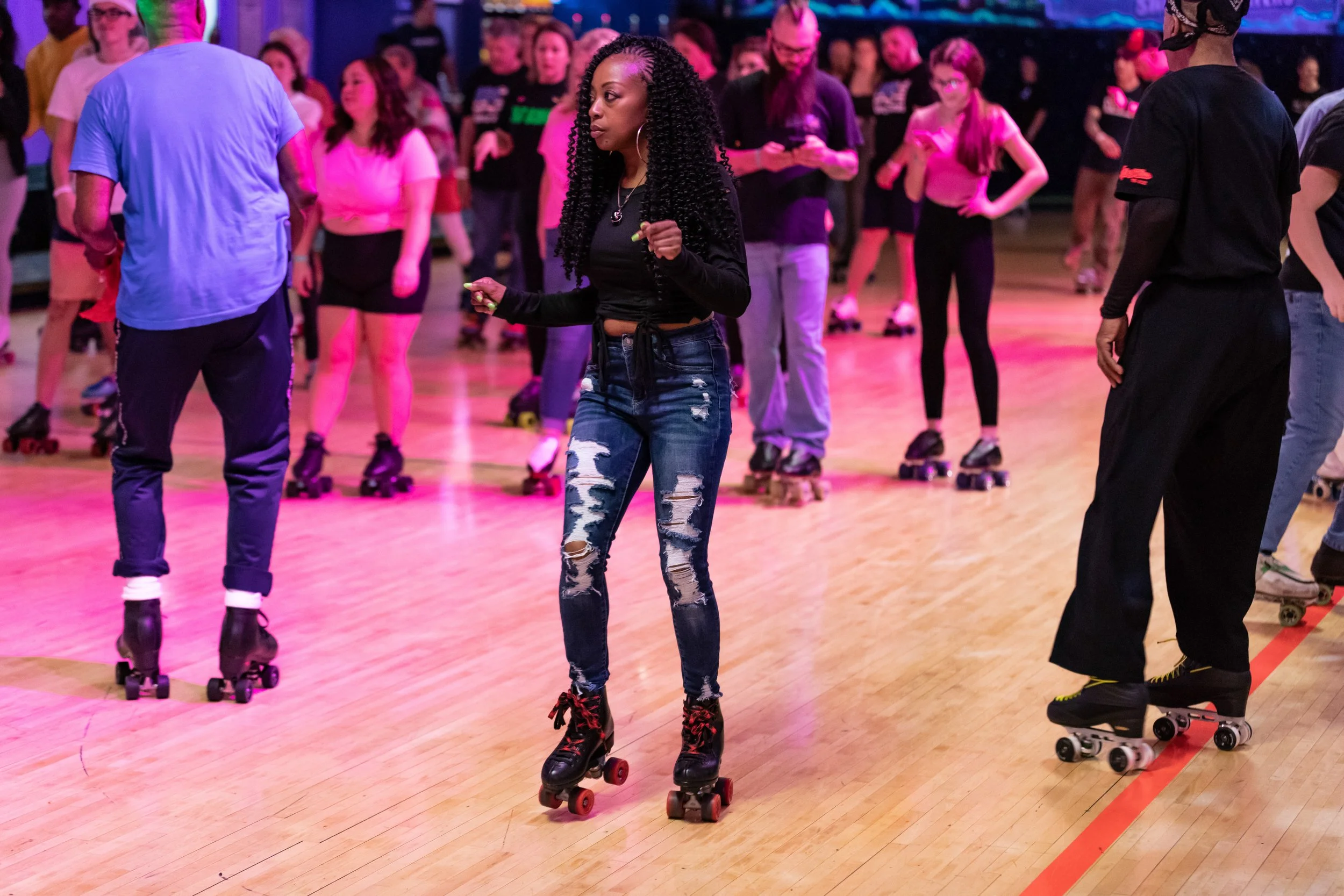 People roller skating in a skating rink with colorful lights