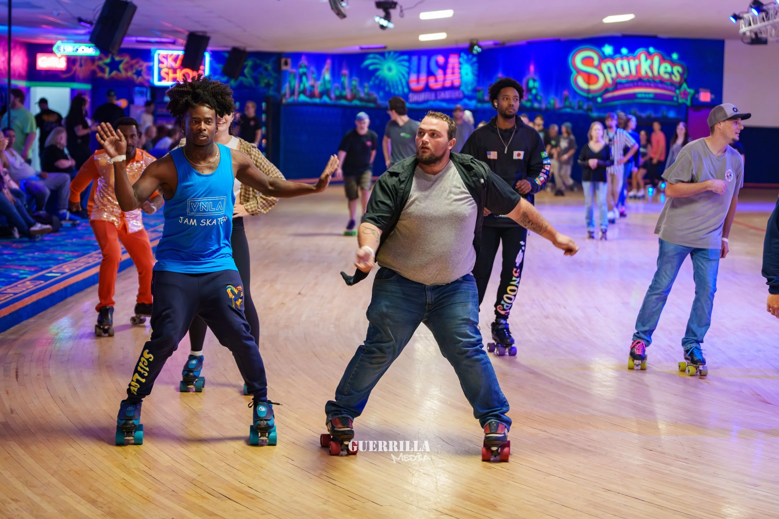 People roller skating in a roller rink with colorful neon signs and decorations in the background.