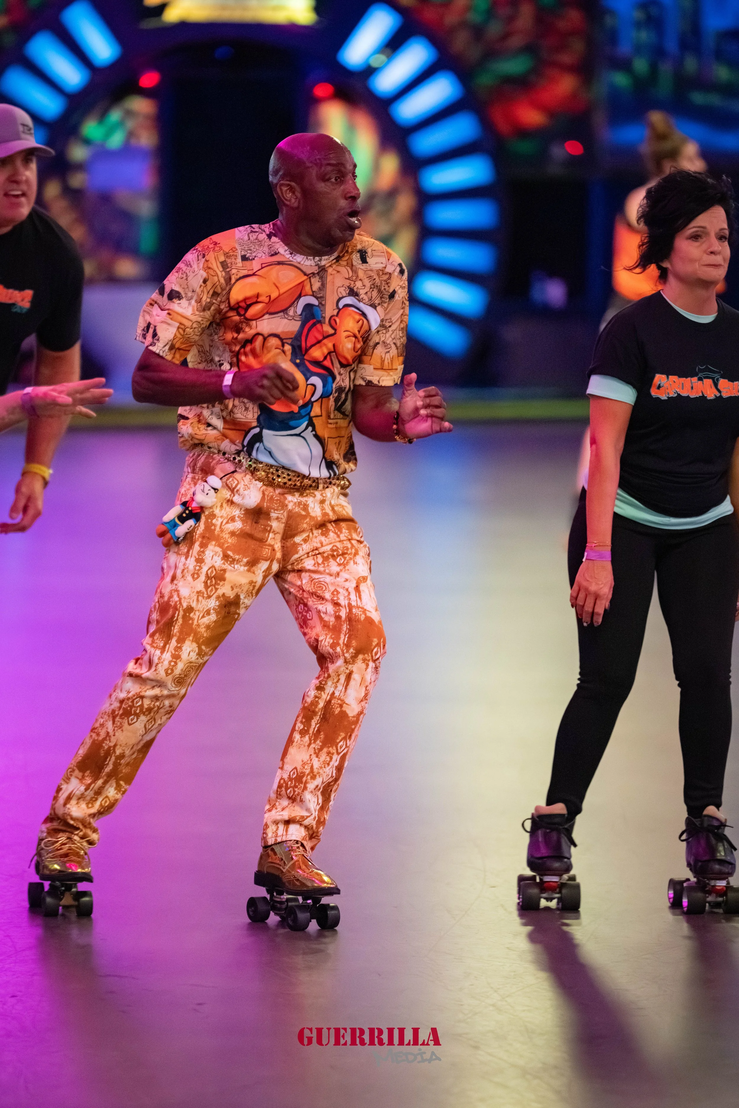 People roller skating indoors with colorful lights and decorations in the background, wearing casual attire.