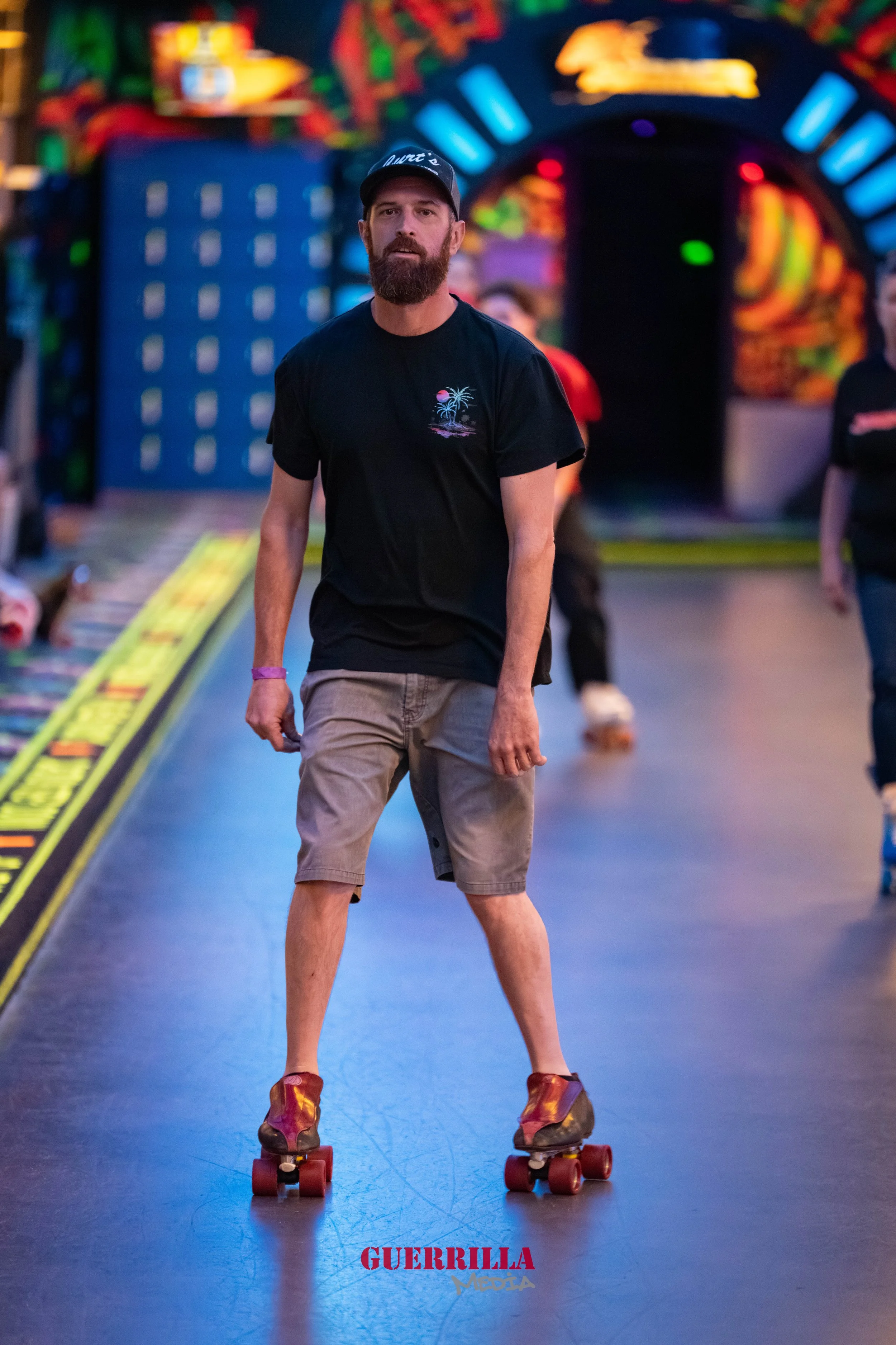 A man roller-skating in an indoor skating rink with colorful neon lights and arcade games in the background.