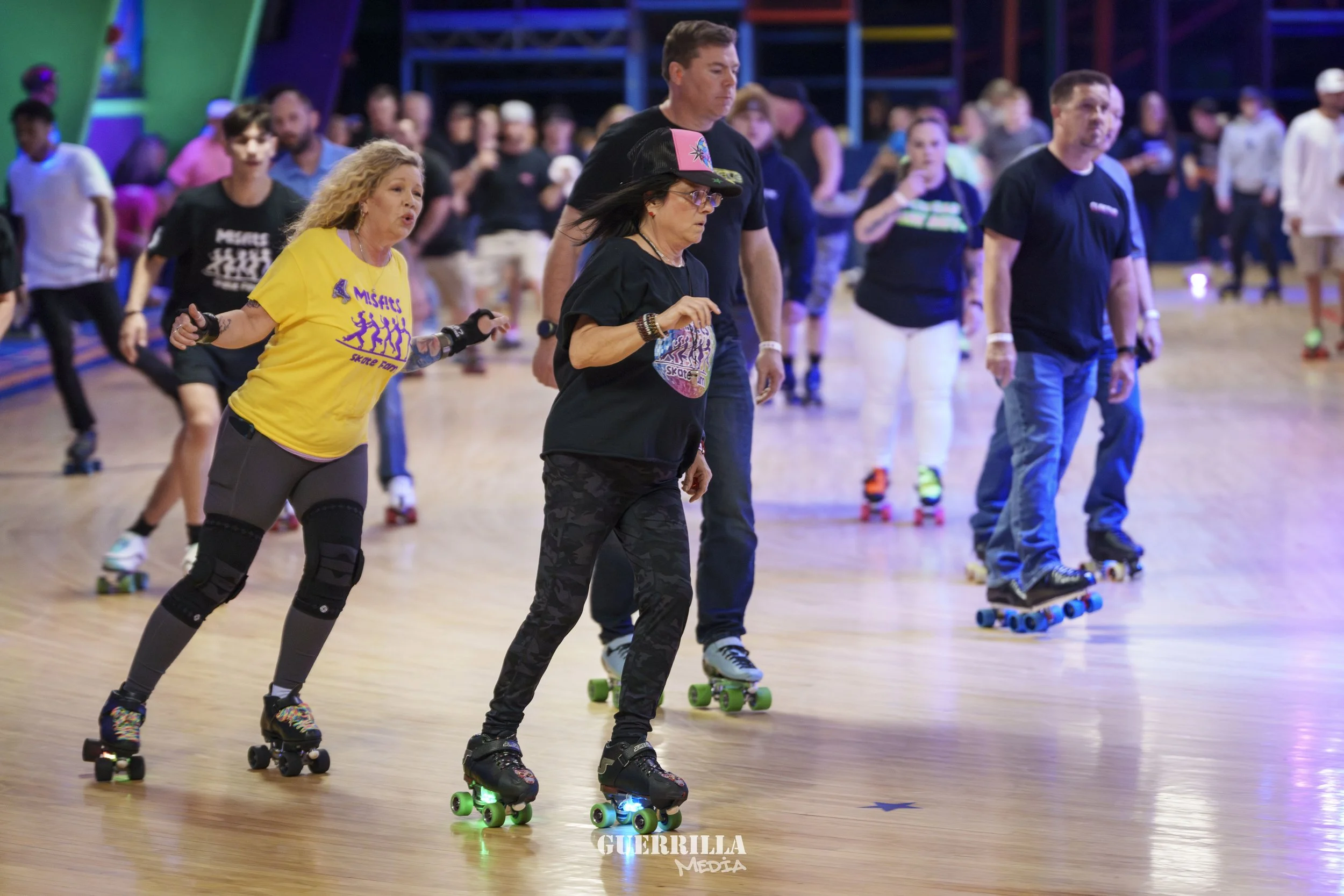 People roller skating indoors, some wearing Misfits band t-shirts.