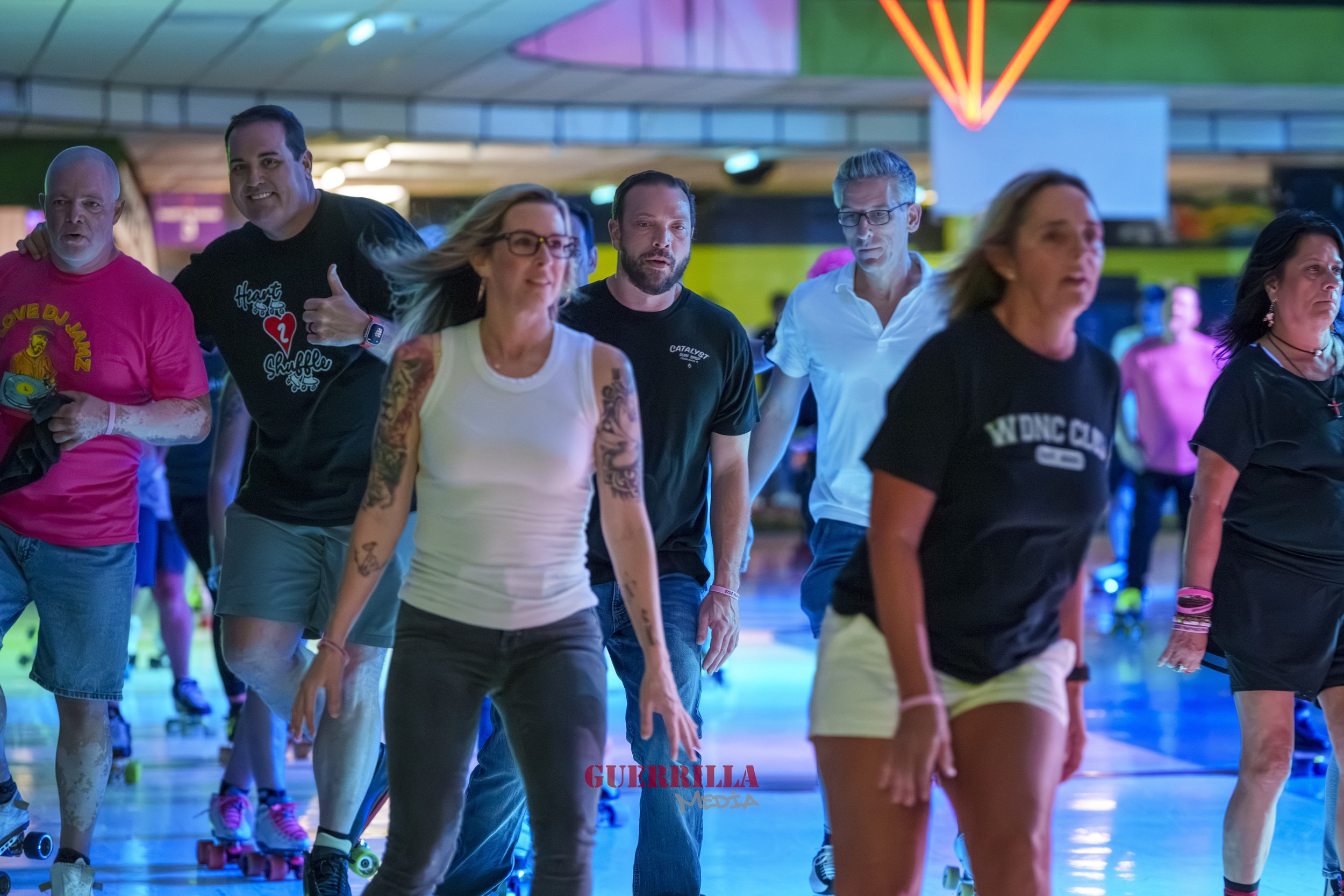 Group of people roller skating in indoors with neon and colored lights