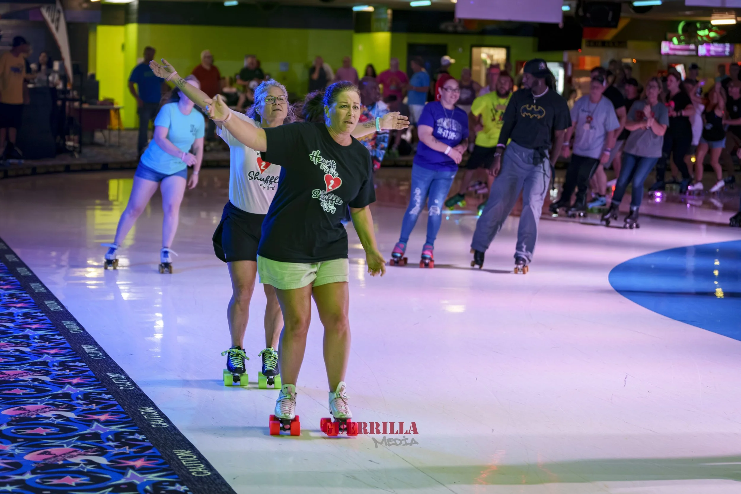 People roller skating indoors, with a group practicing freestyle skills, colorful lighting, and a vibrant arcade-like background.