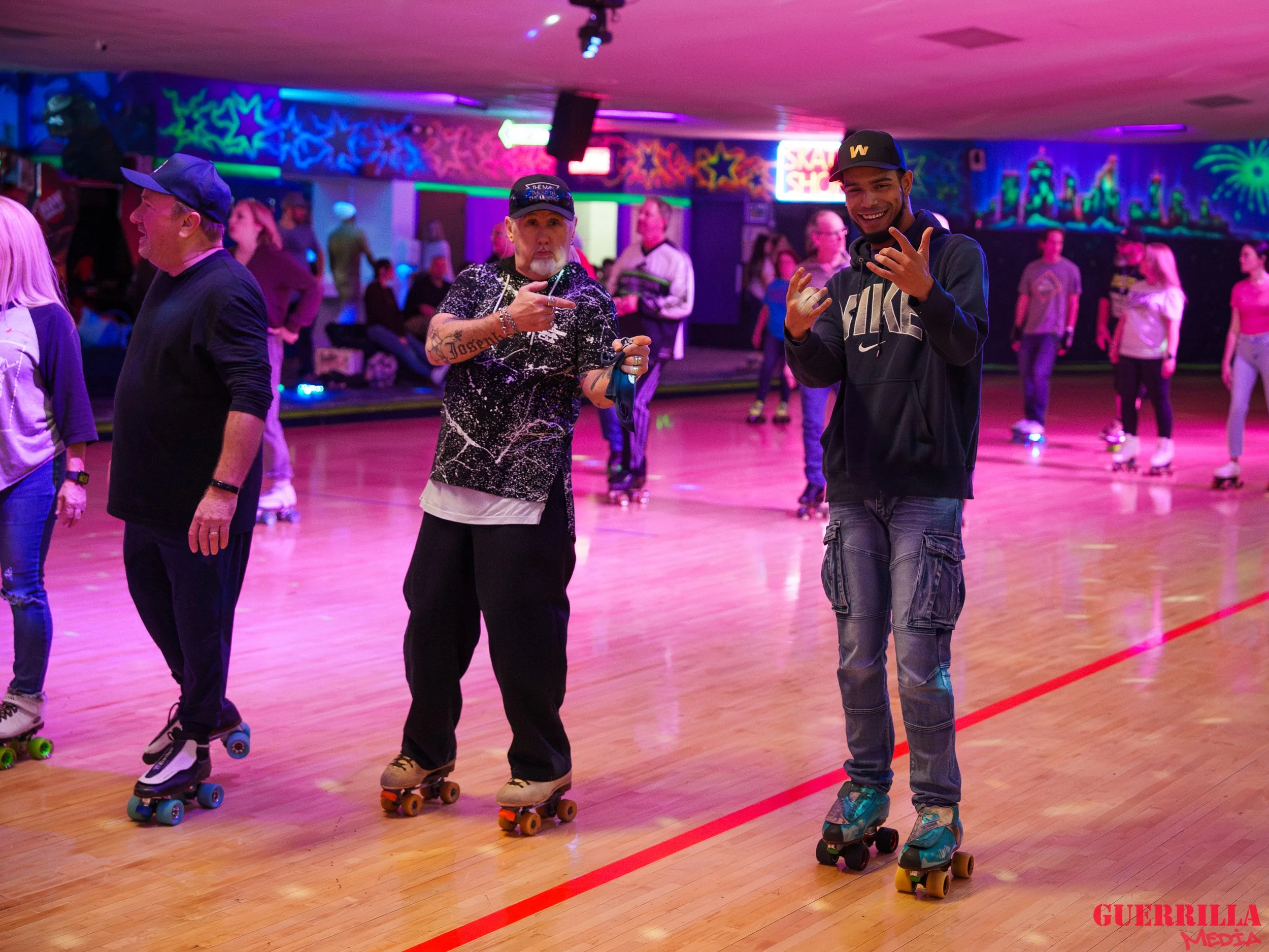 People roller skating at an indoor roller rink with colorful neon and blacklight decorations.