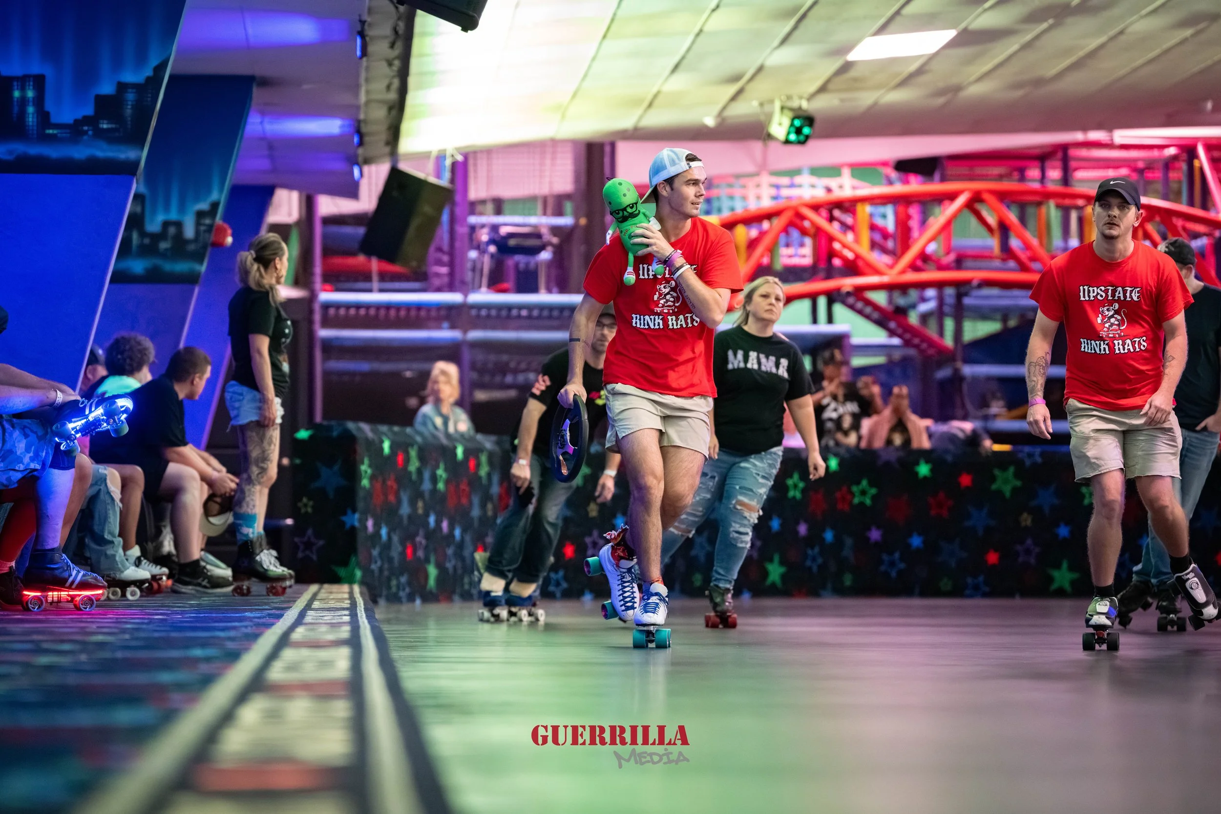 People roller skating at an indoor roller rink with neon lights and colorful decor.