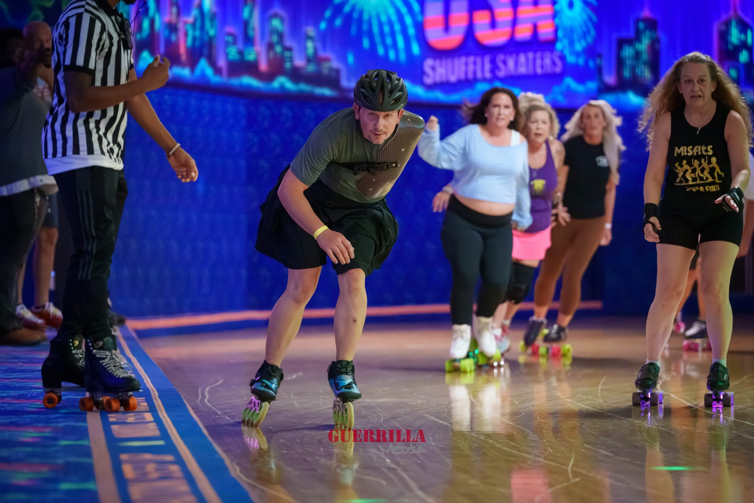 People roller skating indoors, some looking serious, on a wooden floor with neon-lit cityscape background.