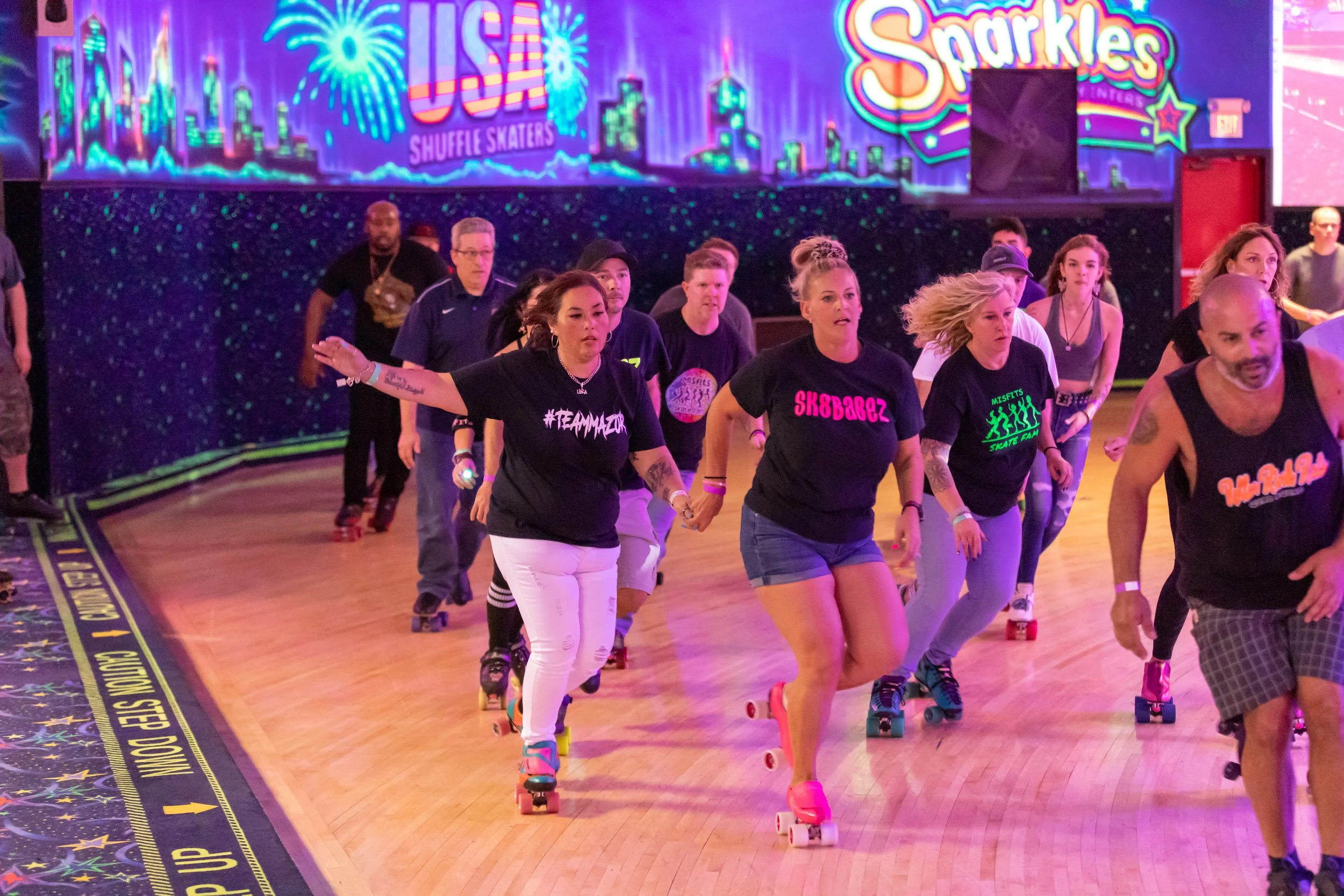 People roller skating at an indoor rink with vibrant, colorful neon signs and cityscape artwork in the background.
