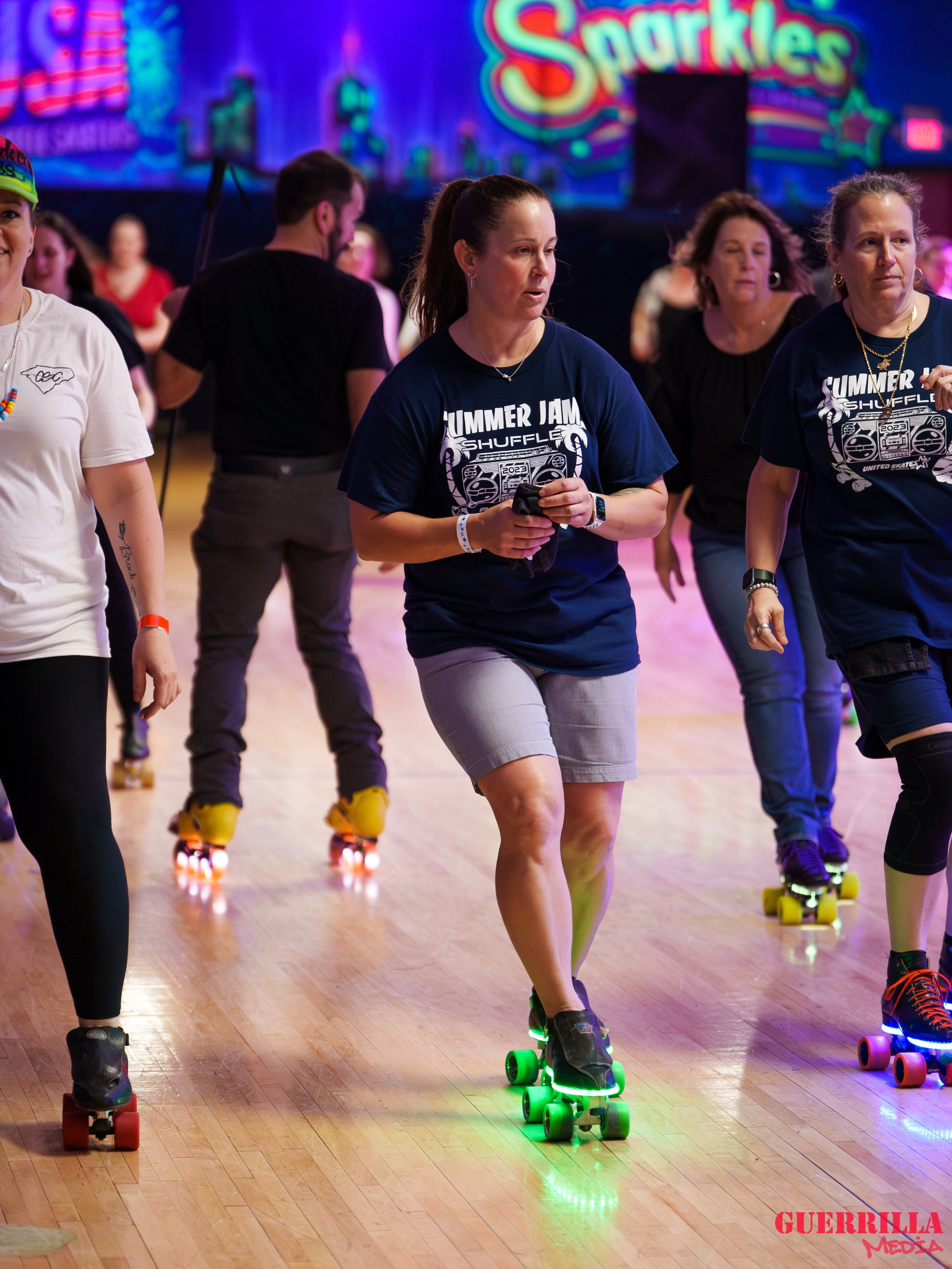 People roller skating during a summer event at an indoor skate rink.