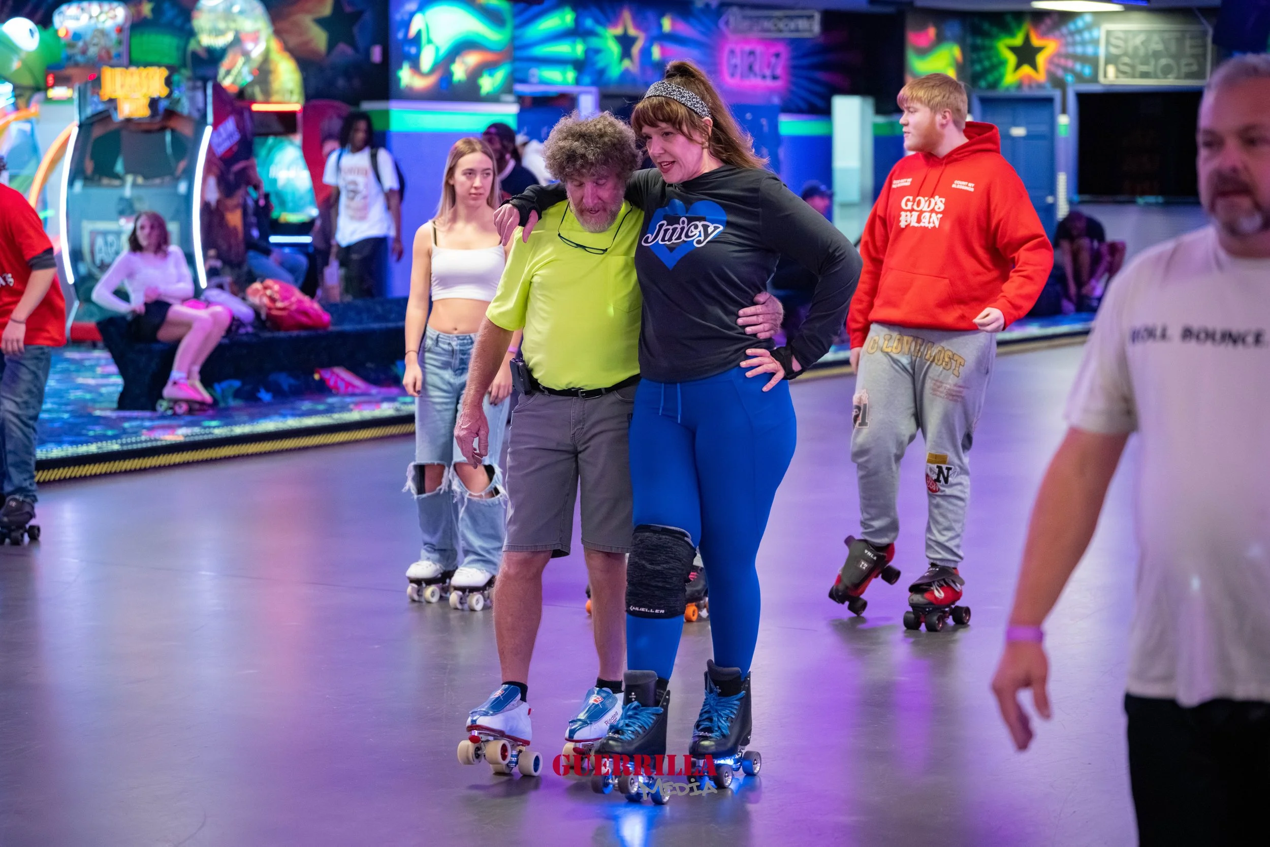 People roller skating at an indoor roller rink with colorful neon lights and arcade games in the background.