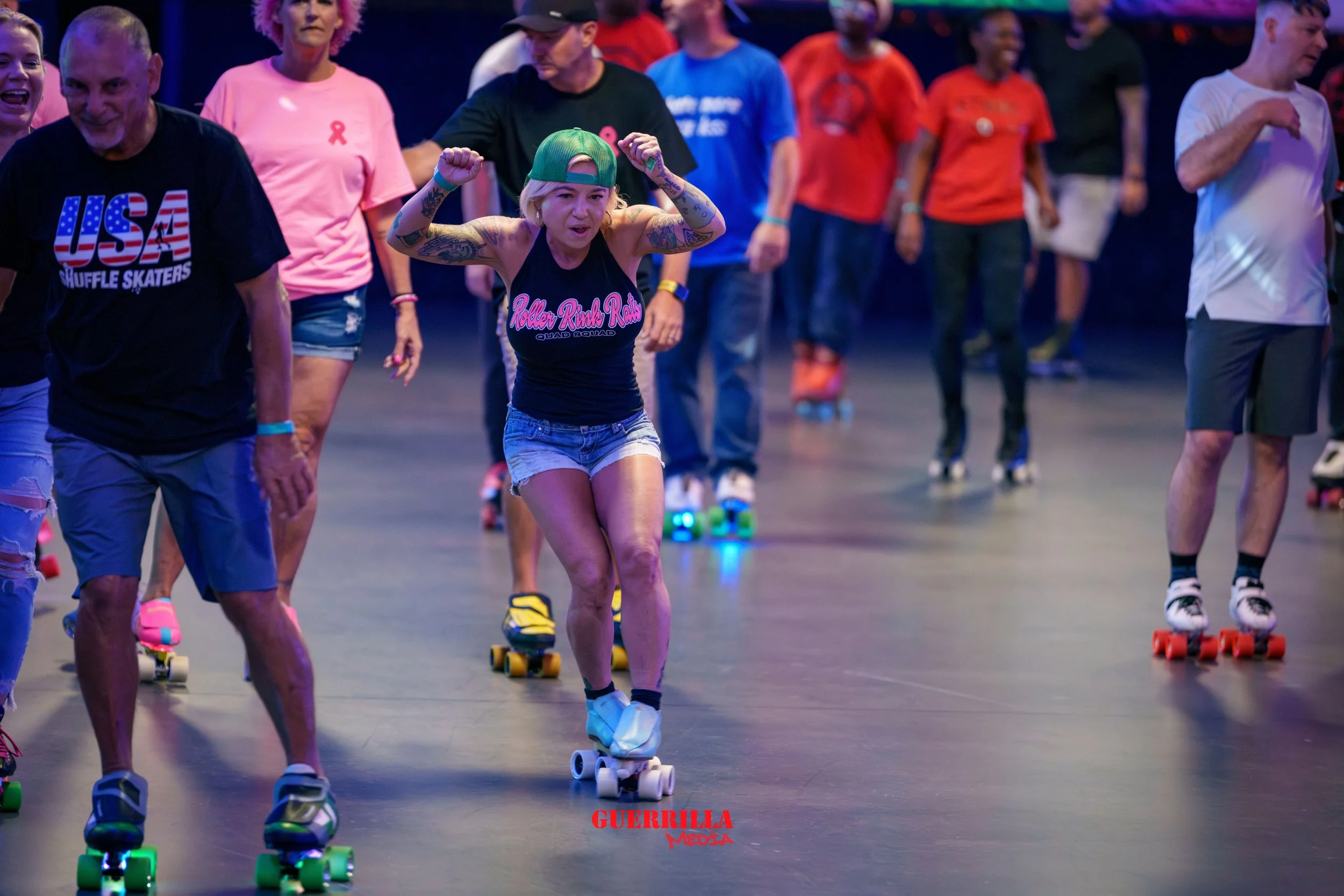 People roller skating in an indoor rink, some wearing casual clothes and some in themed outfits, dancing and having fun.