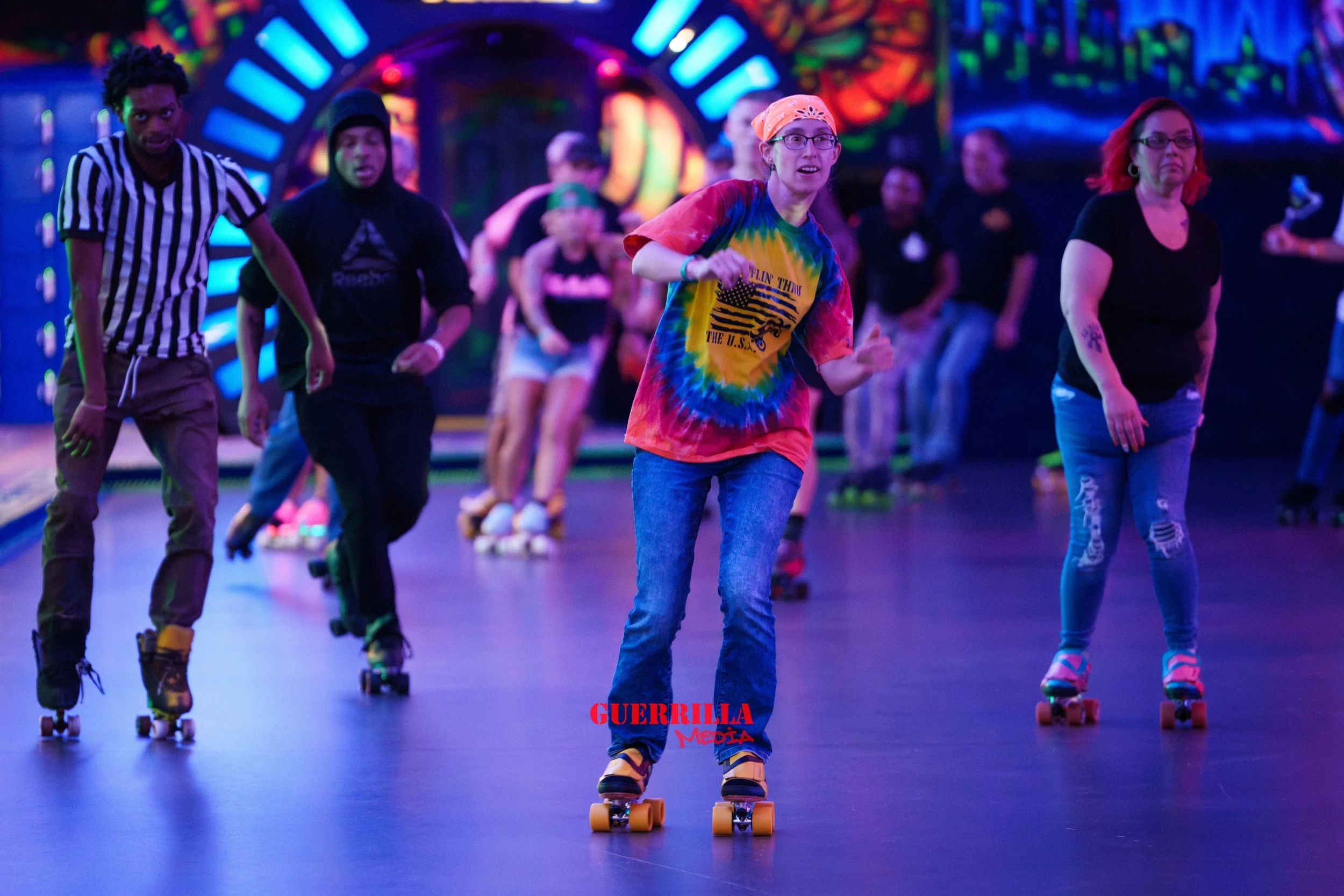 People roller skating in a vibrant, neon-lit indoor roller rink.