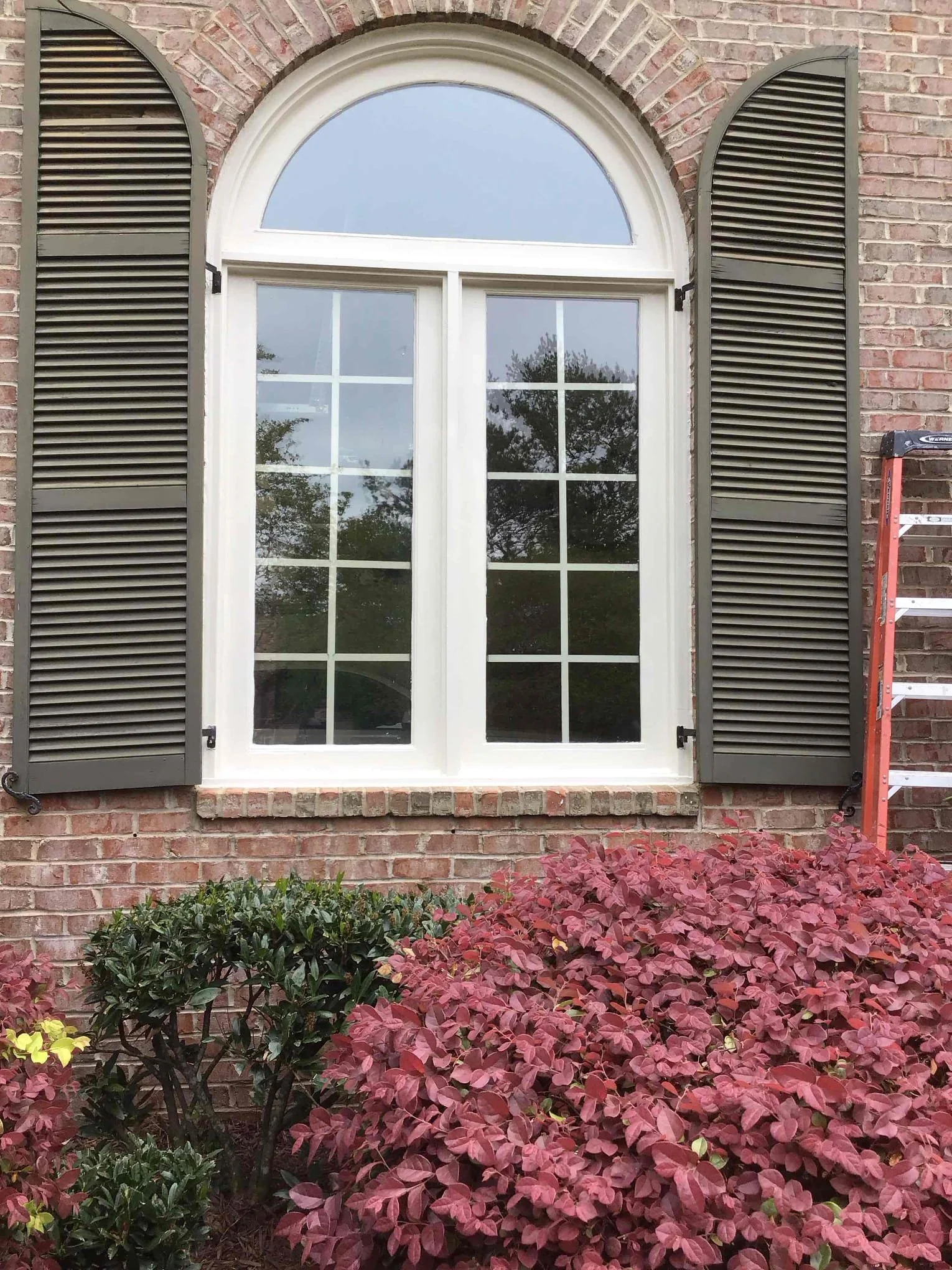 Restored window sash with white trim and arched transom, installed by Mr. Handyman of Tampa and Clearwater on a brick home.