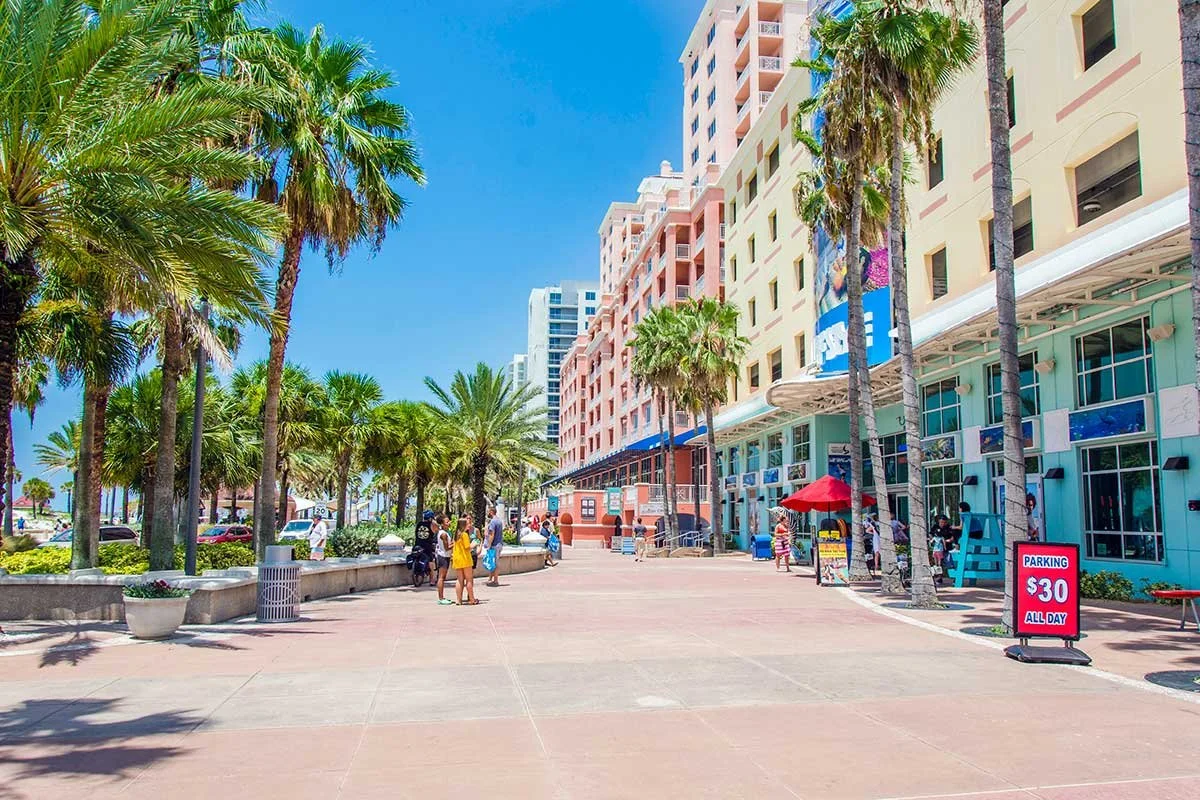 Palm tree-lined shopping promenade near the beach in Clearwater, Florida on a bright sunny day.