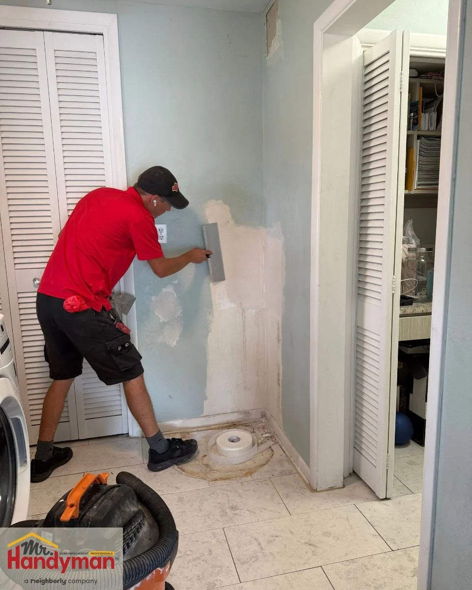 Mr. Handyman technician repairing drywall damage in a Tampa and Clearwater home laundry area.