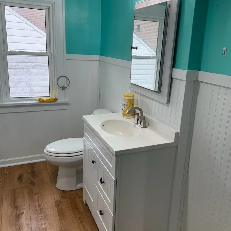 Bathroom remodel with new white vanity, wainscoting, and teal accent wall – Clearwater FL