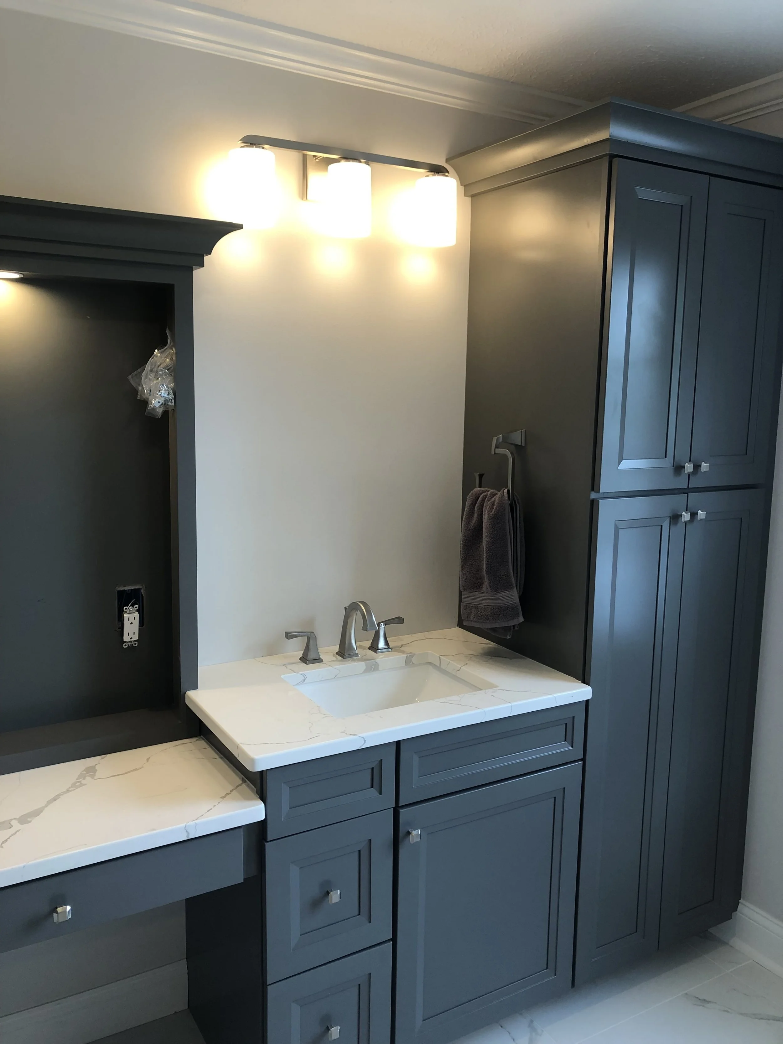 Contemporary bathroom remodel with custom cabinetry, modern lighting, and elegant marble-look surfaces.