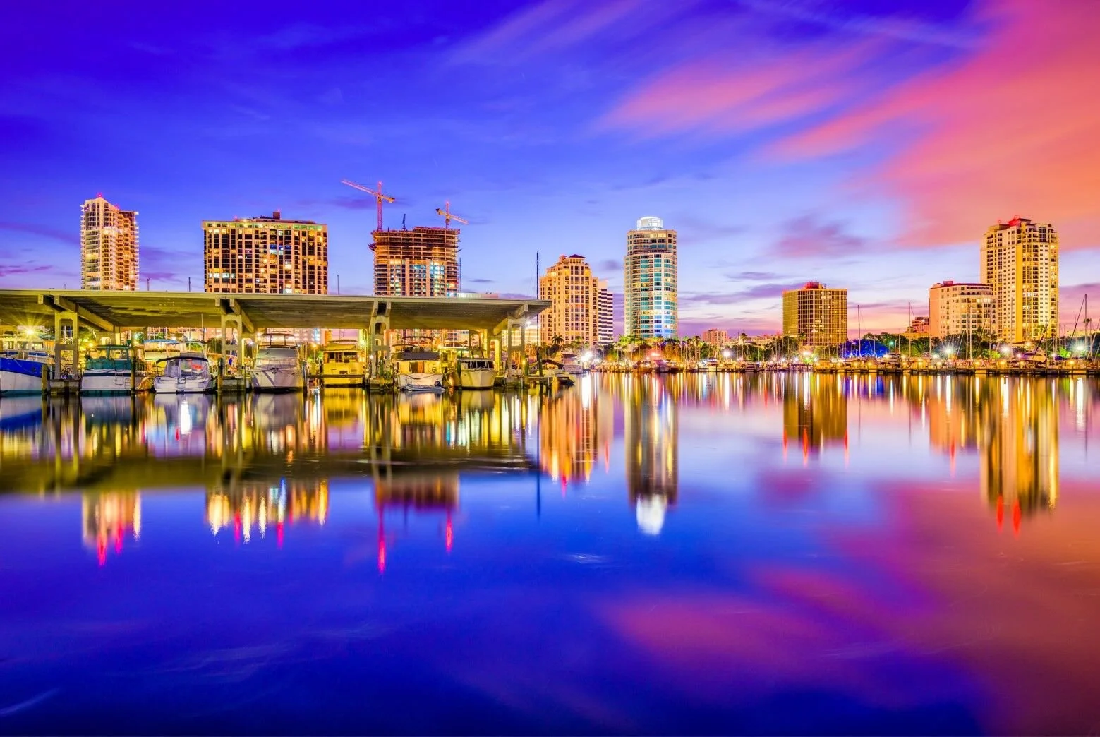 Colorful twilight reflecting on the water in downtown St. Petersburg with high-rise buildings and marina