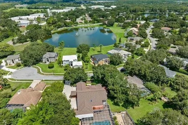 Aerial view of a residential neighborhood with a central lake in Odessa, FL.