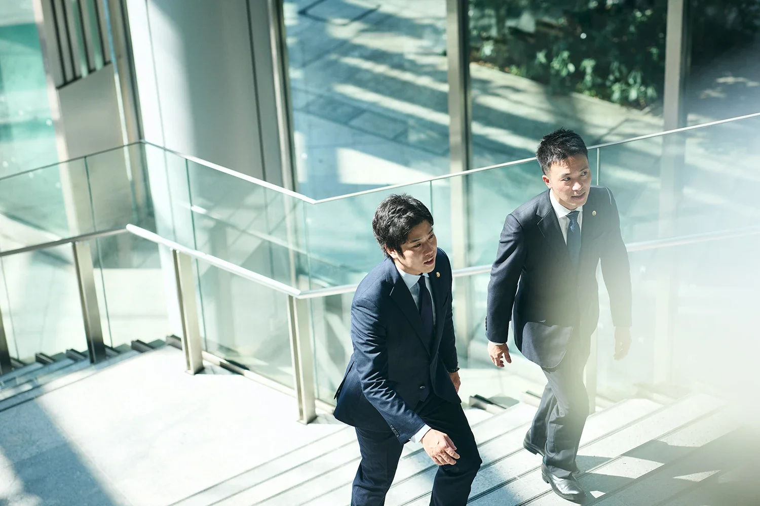 ビジネスマン二人が階段を上がっている