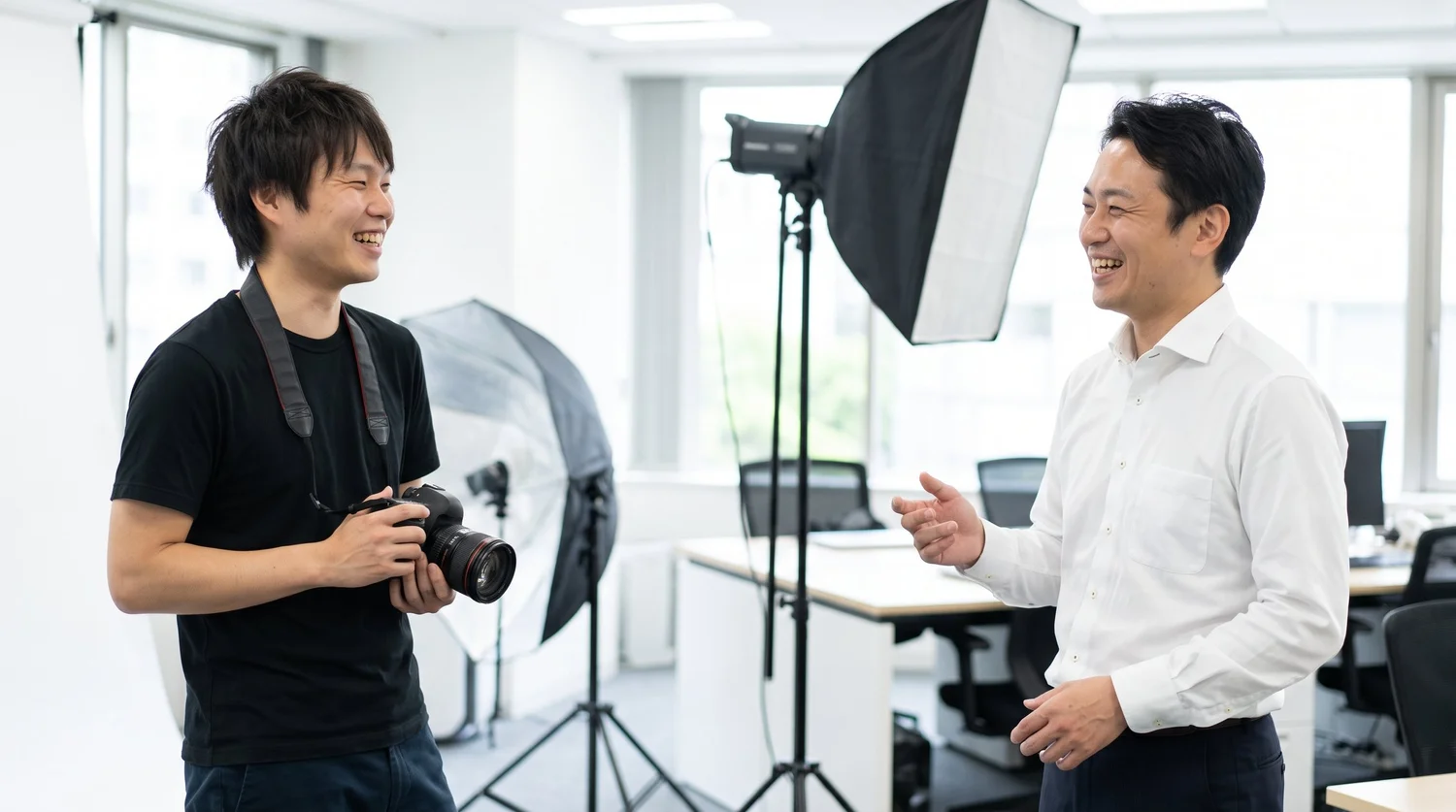 カメラマンが社員の方と雑談をしながら、笑顔でプロフィール写真の撮影を進めている様子