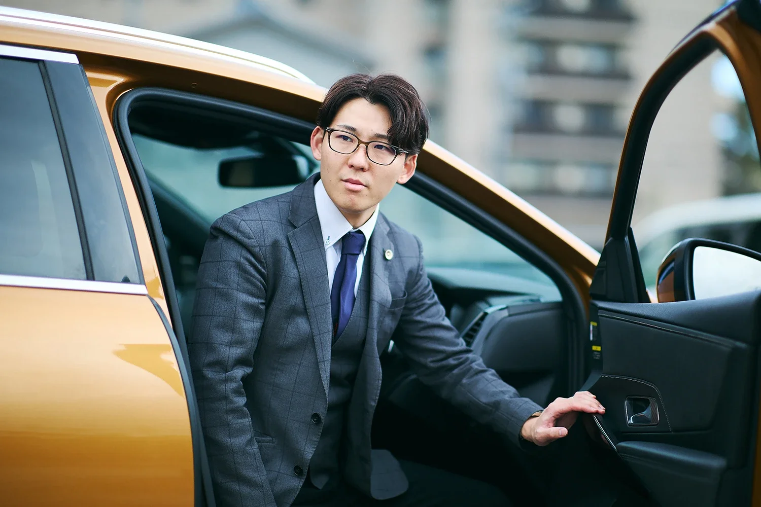 ビジネススーツを着た男性が車の中から外を見ている