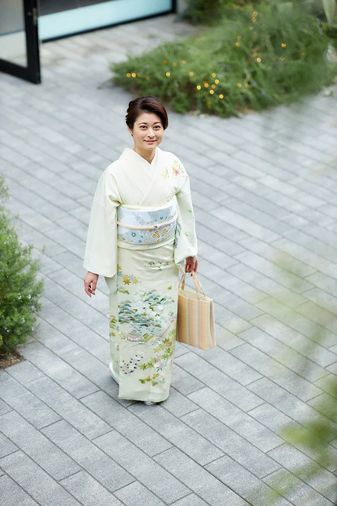 白い着物を着た女性が歩いている。