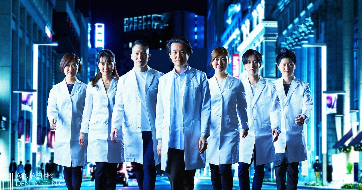 都市の夜景の中、白衣を着た医療スタッフが並んで歩いている写真