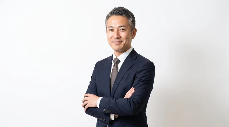 白背景で腕を組むビジネスパーソンの広報用イメージ写真