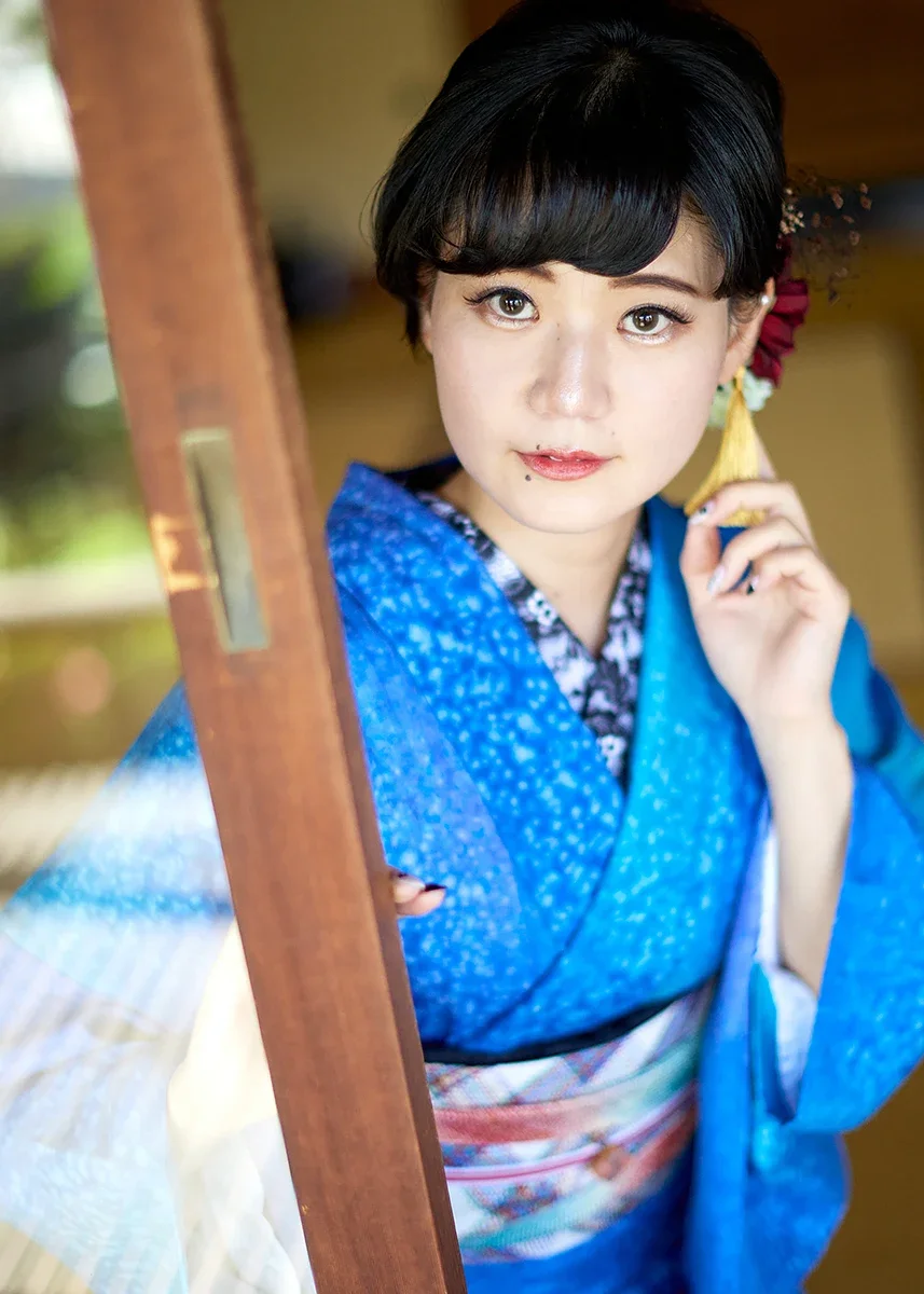 着物を着た若い女性が鏡の前で微笑んでいる写真