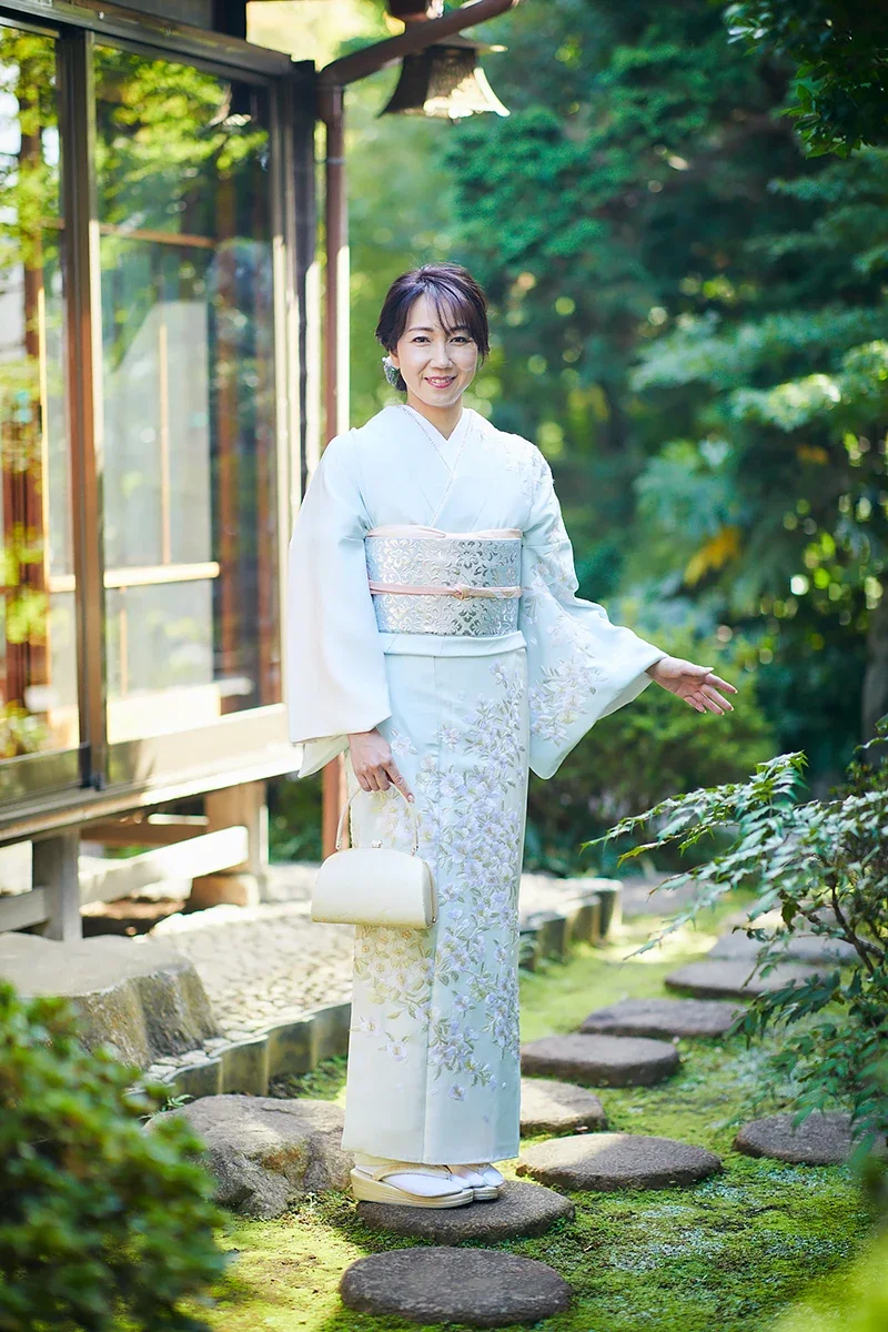 庭園で着物を着た女性が微笑んでいる