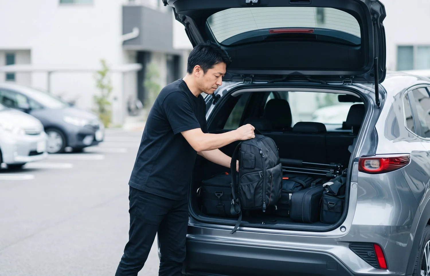出張撮影に向けて撮影機材を車に積み込むカメラマン｜法人撮影の出張費・料金のイメージ