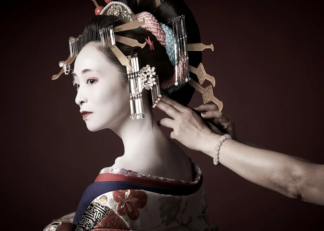 花魁撮影。着物を着た女性の横顔と伝統的なヘアスタイルを整えるヘアメイク