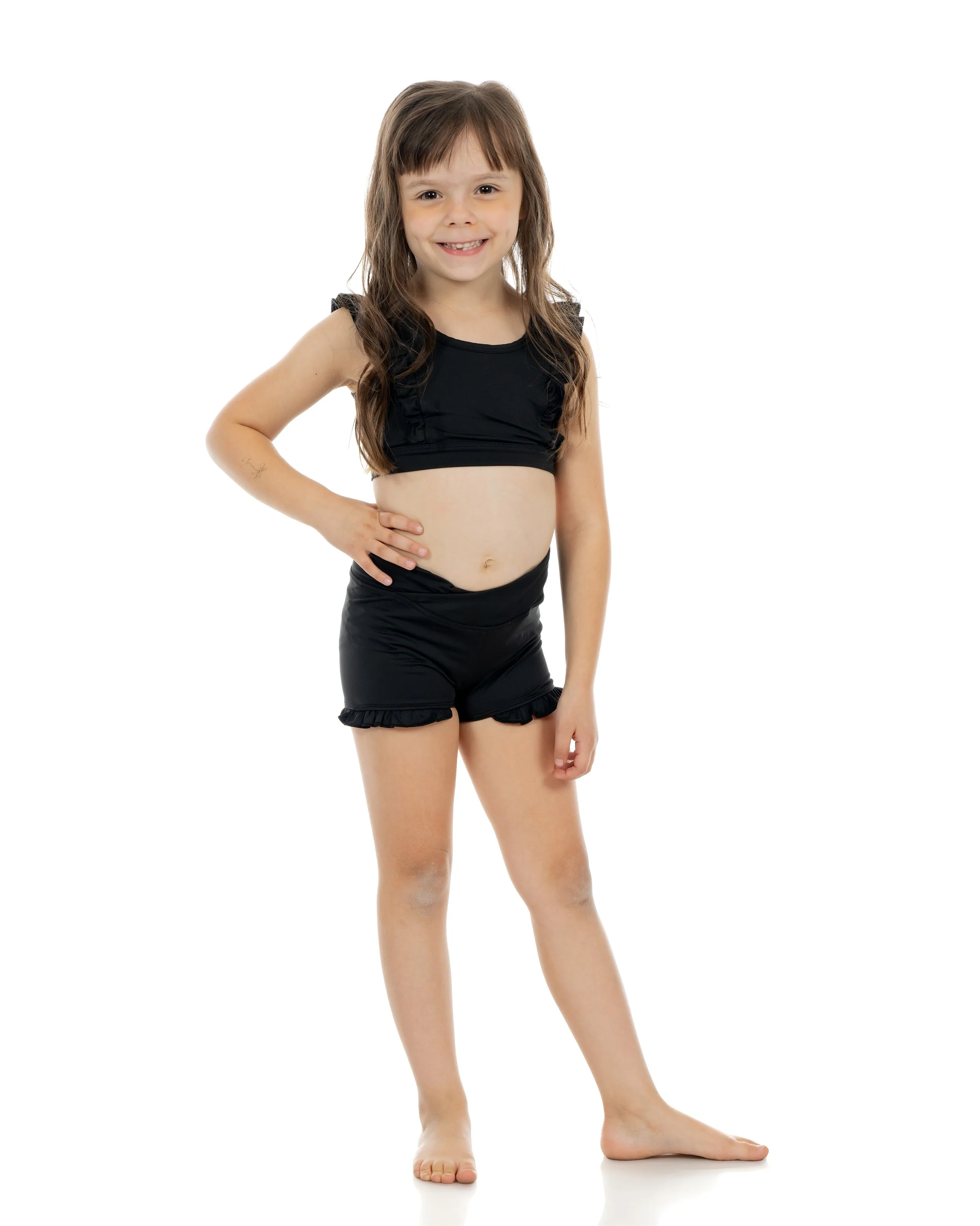 Young dancer smiling confidently in black athletic wear at NJ Dance To Inspire dance studio in Wyckoff, New Jersey.