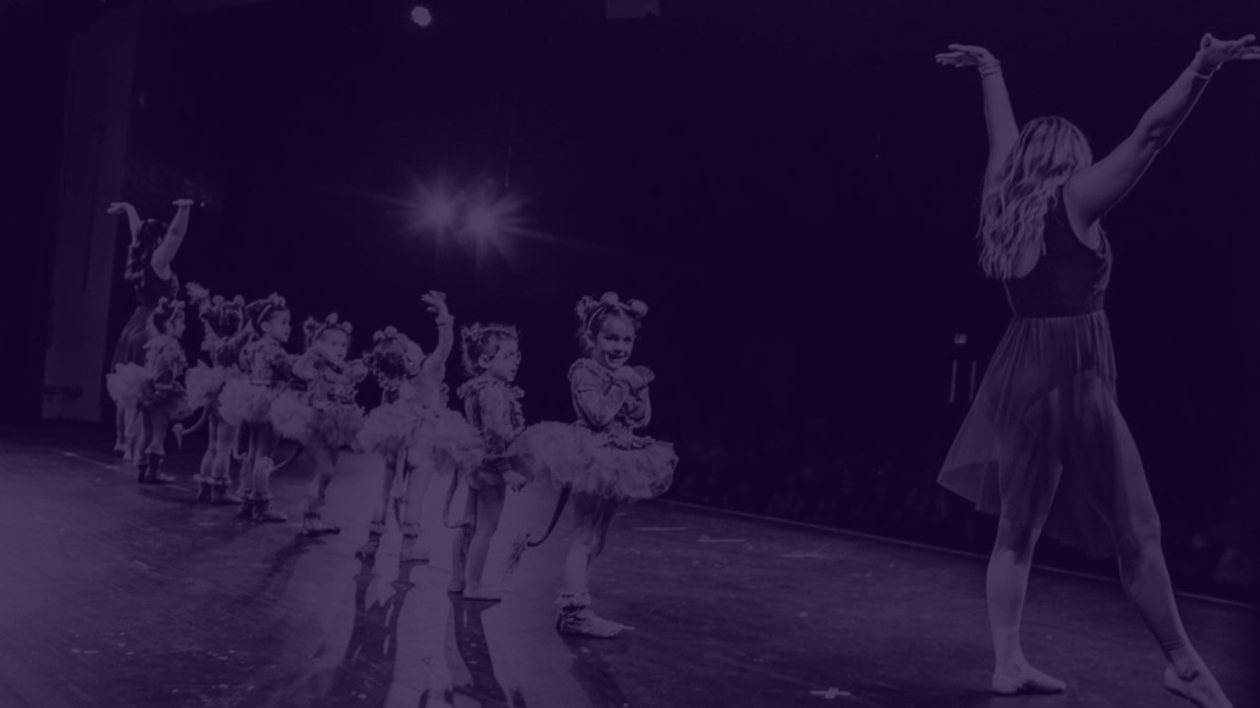 Young ballet dancers performing on stage with an instructor leading the choreography during a NJ Dance To Inspire recital in Wyckoff, NJ.