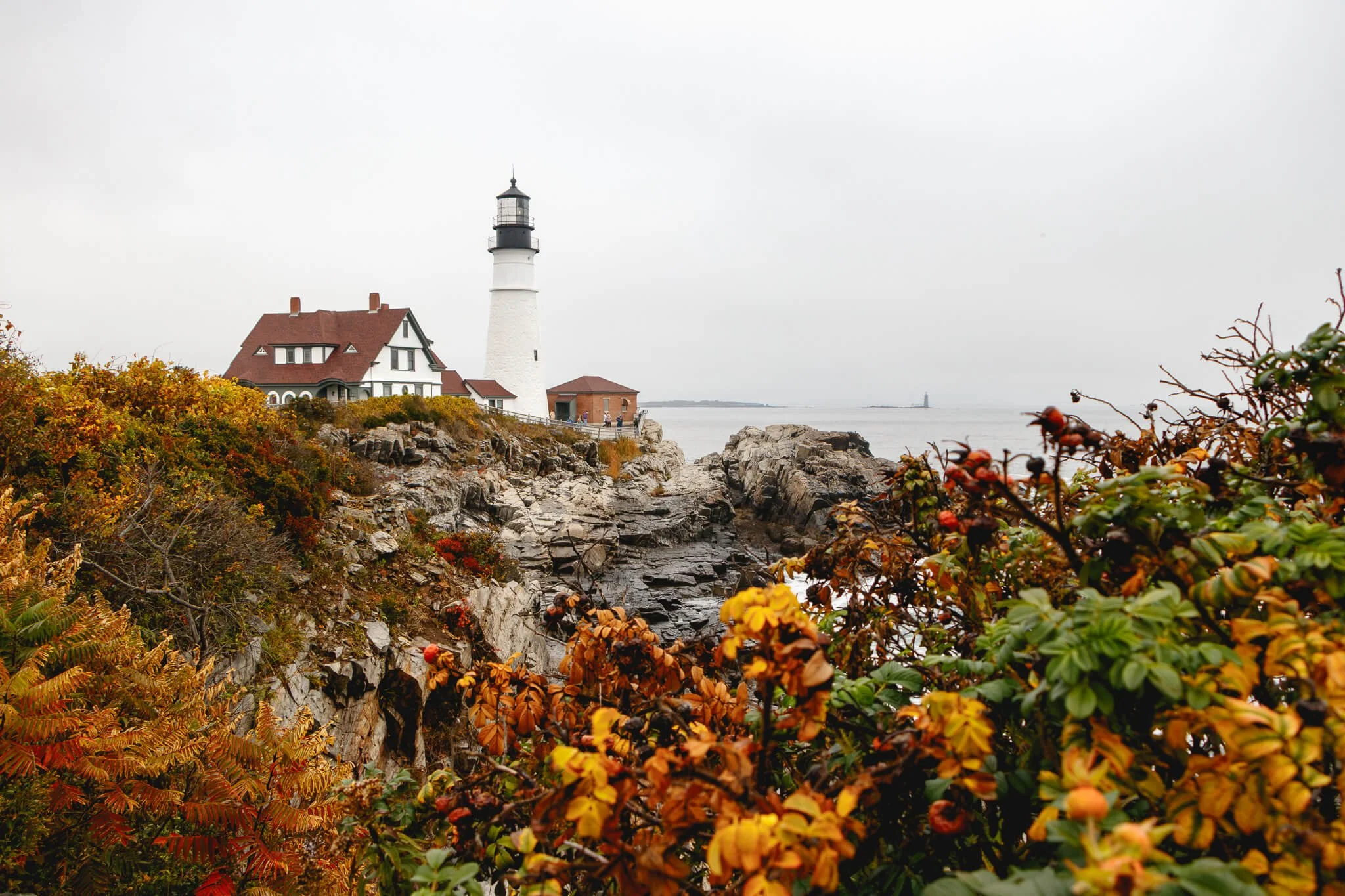 Portland Head Lighthouse in Maine with fall foliage in the foreground