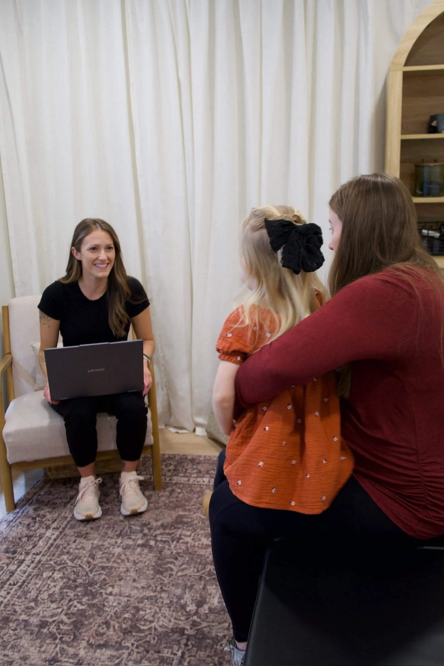 Female chiropractor conducting a detailed history and examination for a family who is starting chiropractic care.
