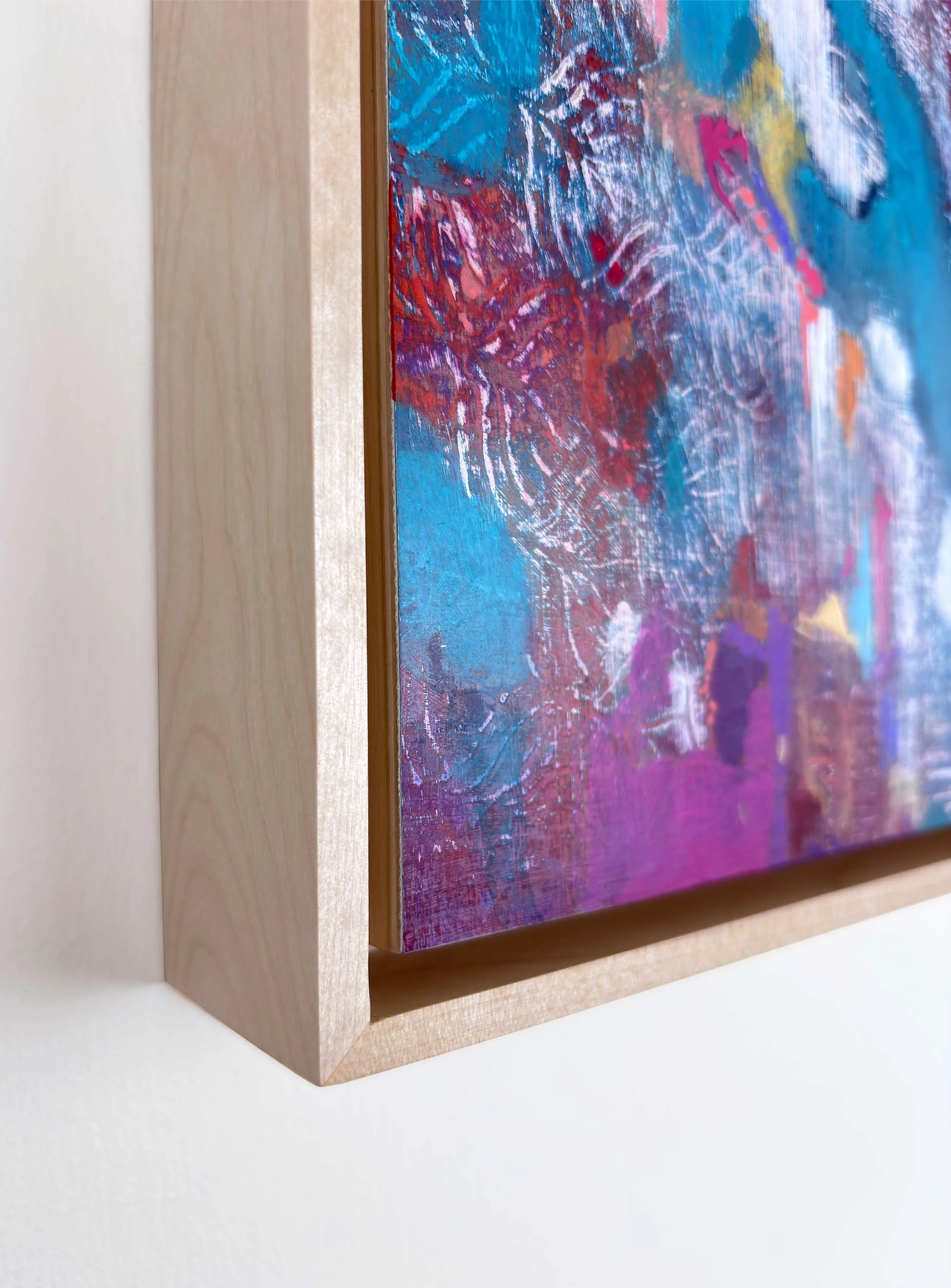 Corner detail of “Drift of Blue” by Calie Durant, framed in light maple wood, showing surface texture and craftsmanship.