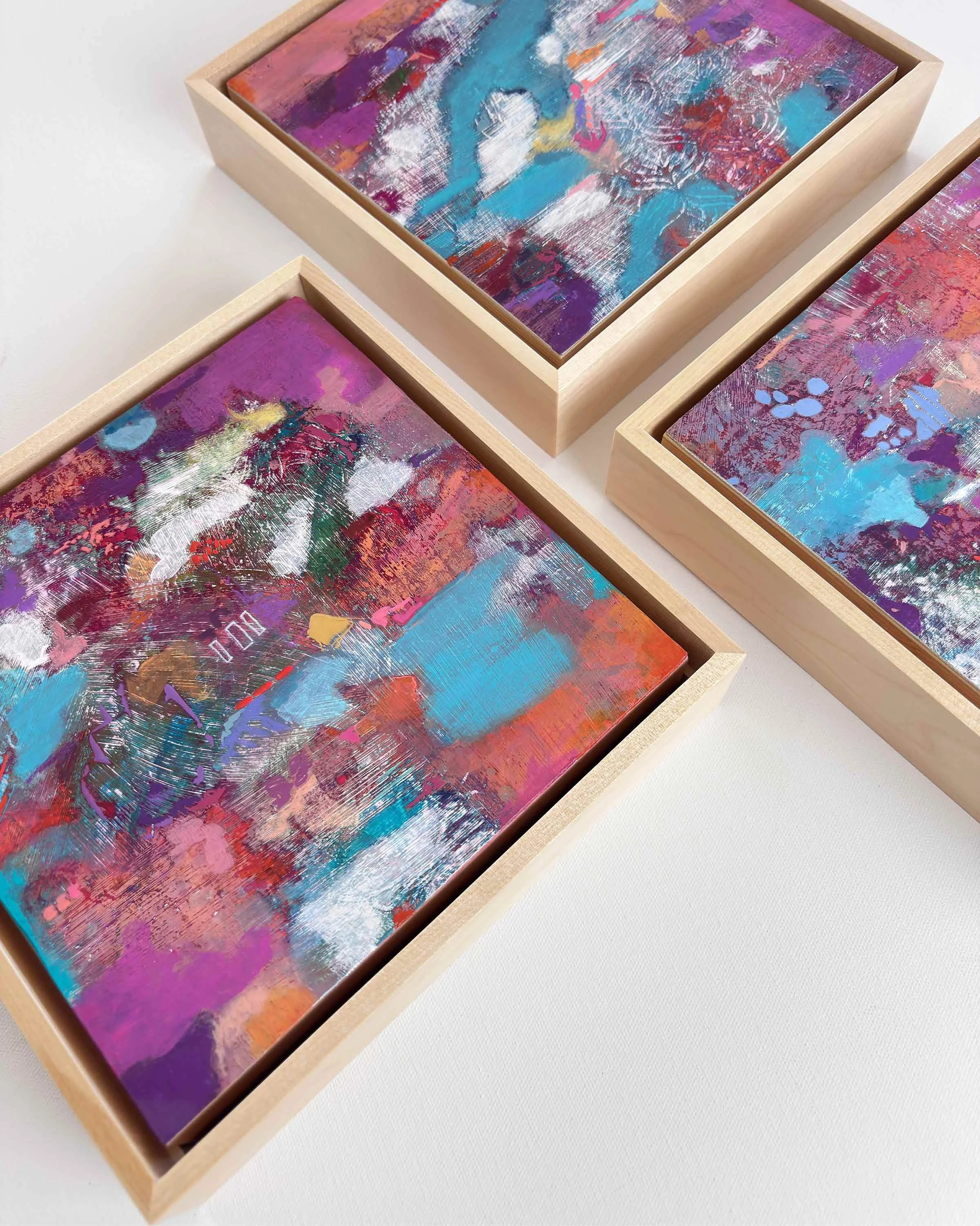 “Violet Current” by Calie Durant shown as part of the Small Wonders series, a trio of abstract paintings displayed together.