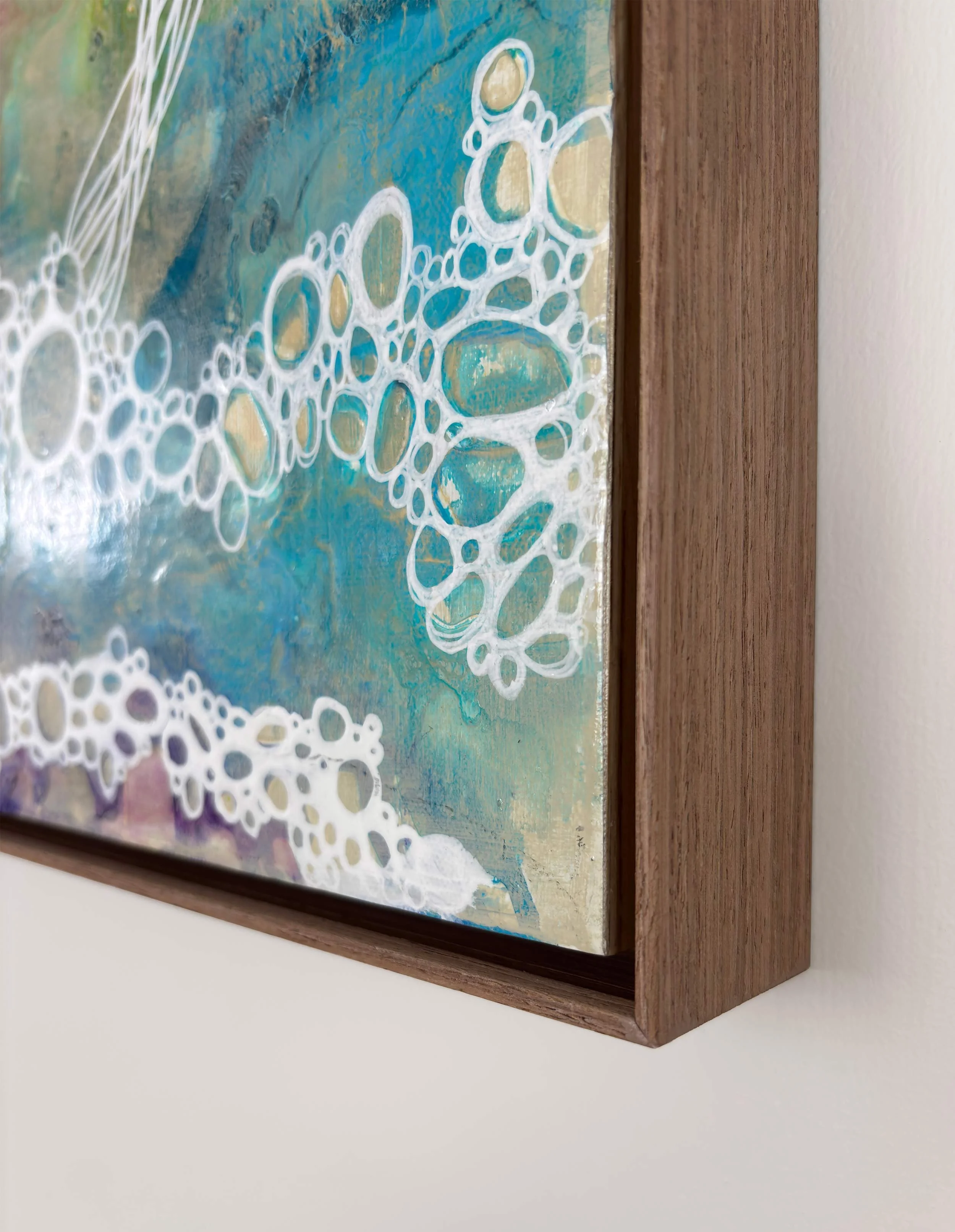 Corner detail of “Reflection” by Calie Durant, framed in light maple wood, showing surface texture and fine craftsmanship.