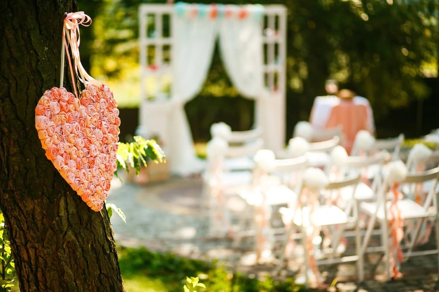 outdoor wedding venue, roses, and white rental chairs.