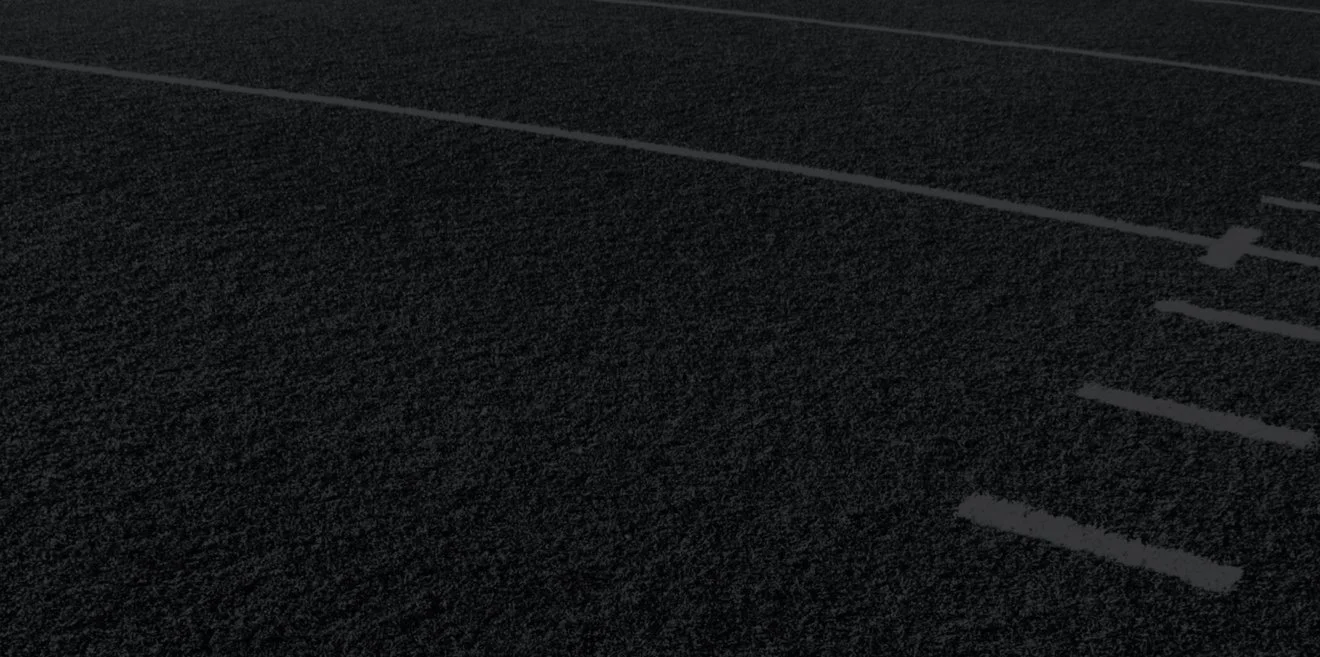 A dark, empty parking lot at night with marked parking spaces.