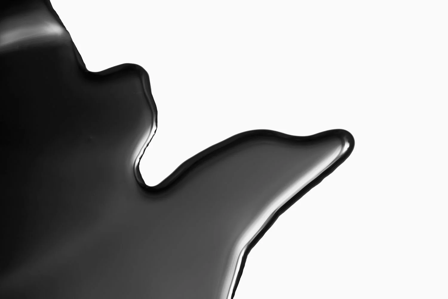 Close-up of a black, glossy, abstract shape with smooth curves on a white background.