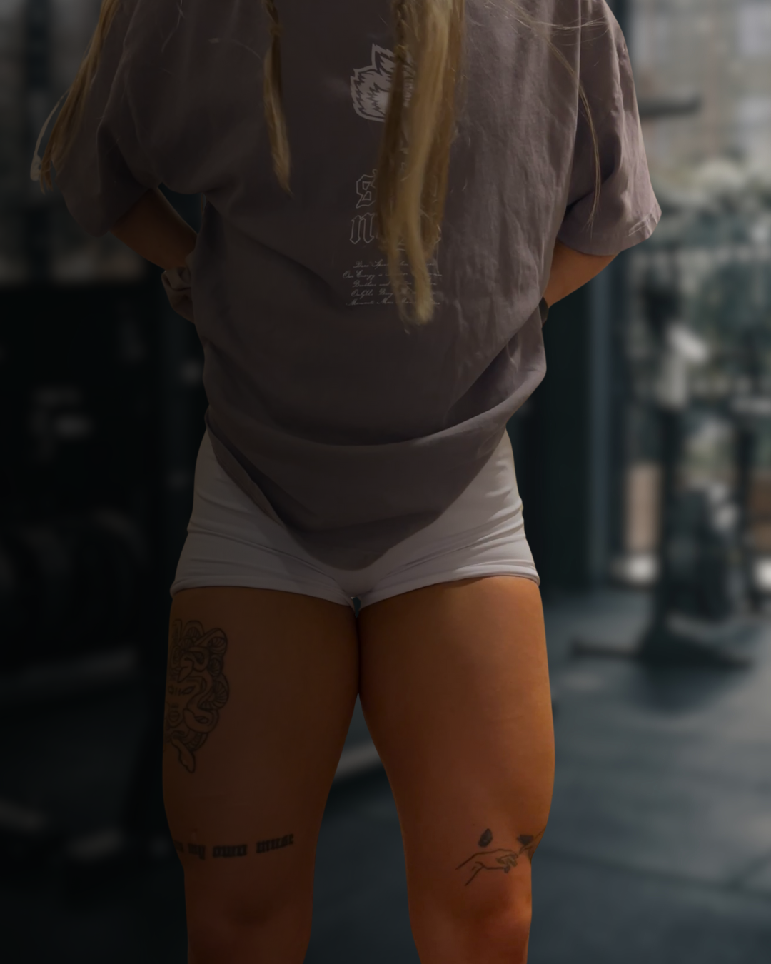 Coach Bre standing in a gym, highlighting lower body strength developed through recovery and training.