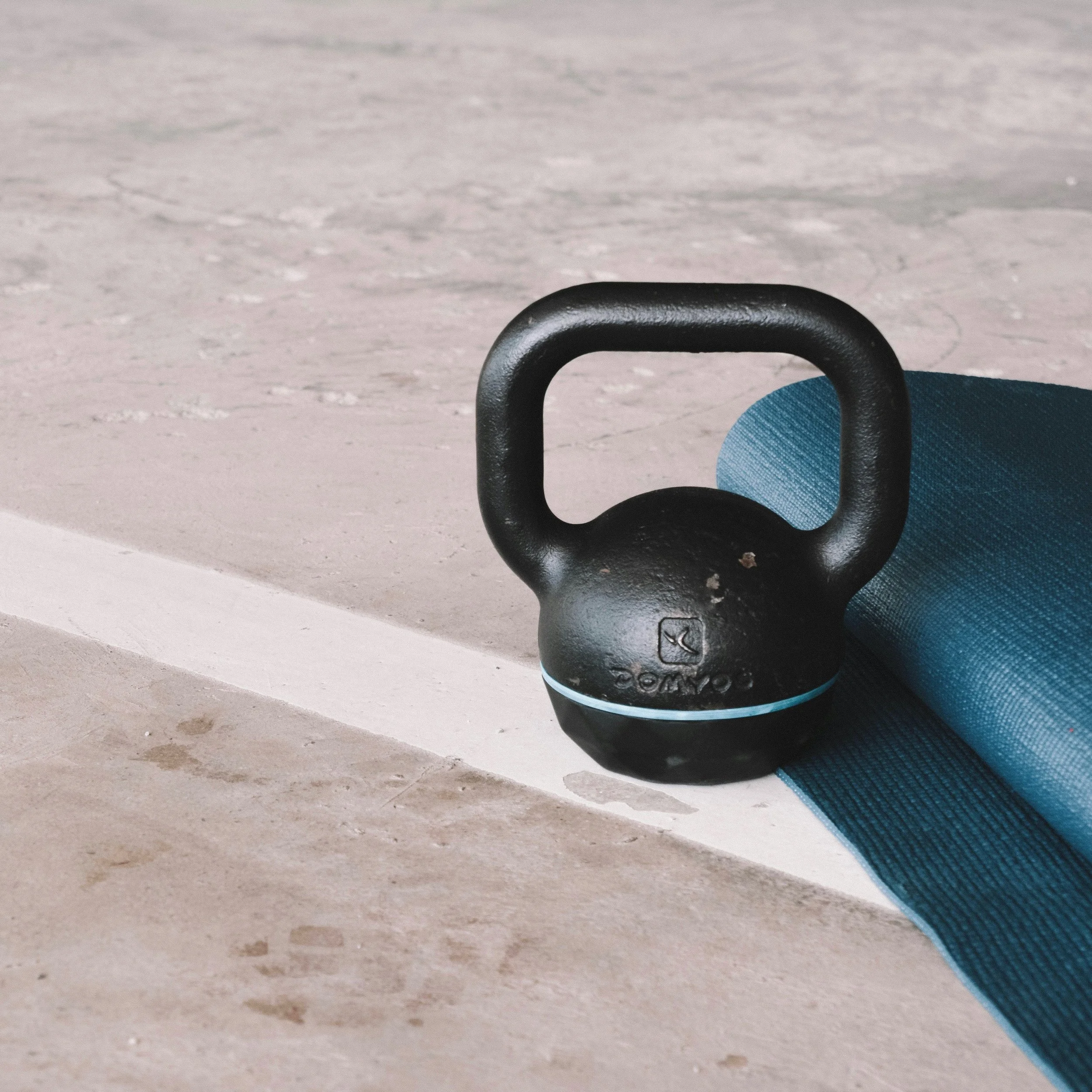 Kettlebell and yoga mat on gym floor used for strength and mobility training