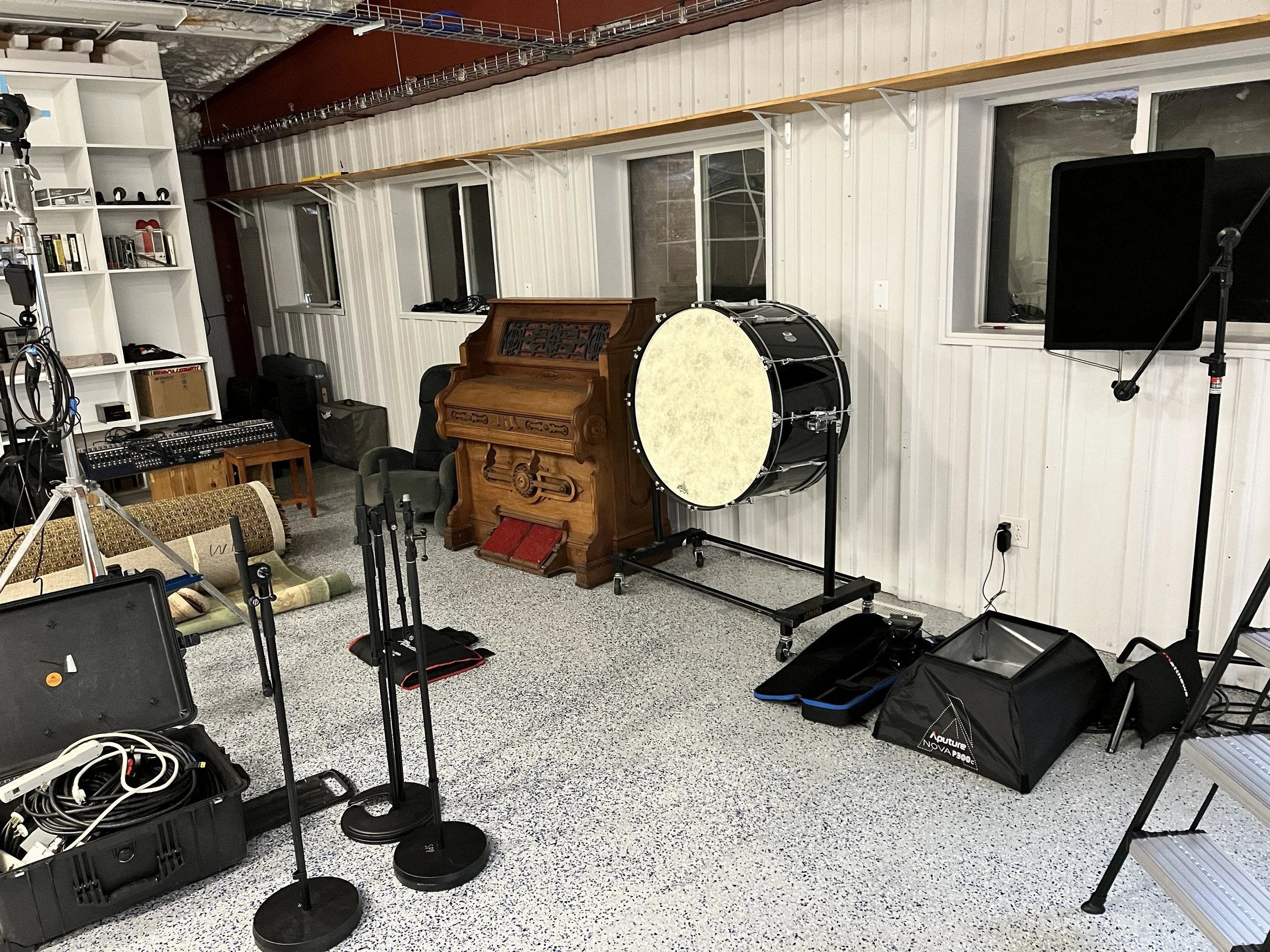 Music studio room with musical instruments, microphones, and recording equipment.