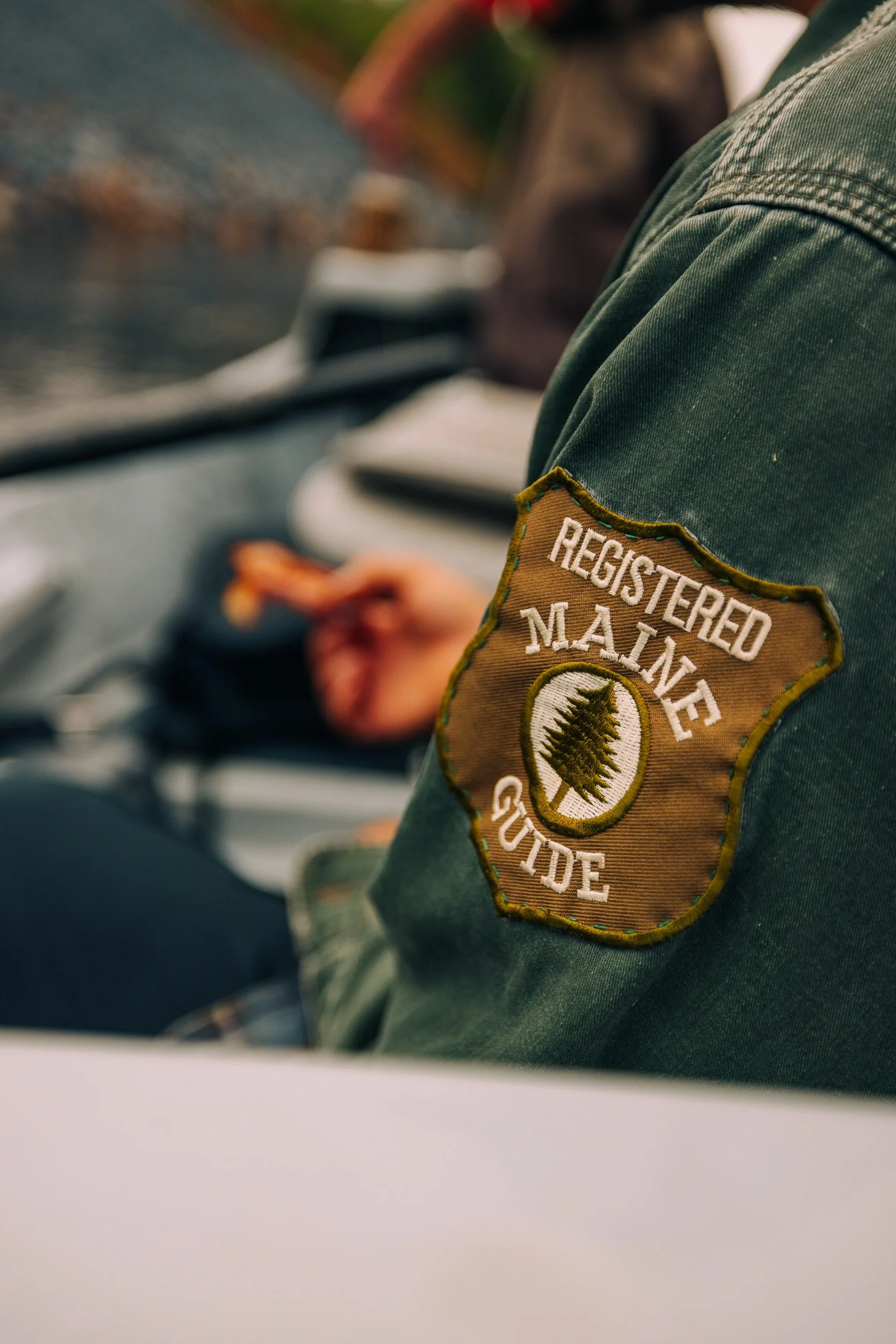 Close-up of a park ranger or guide's shoulder patch that says 'Registered Marine Guide' with an emblem of a pine tree.