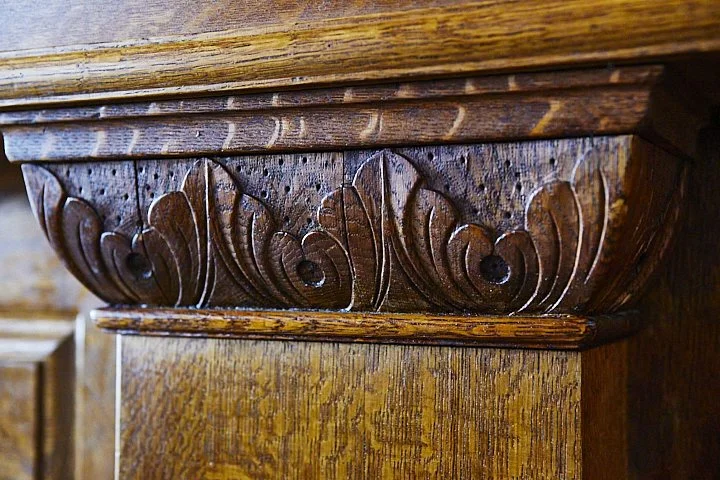 Close-up of carved wooden decorative molding on a piece of furniture or architecture.